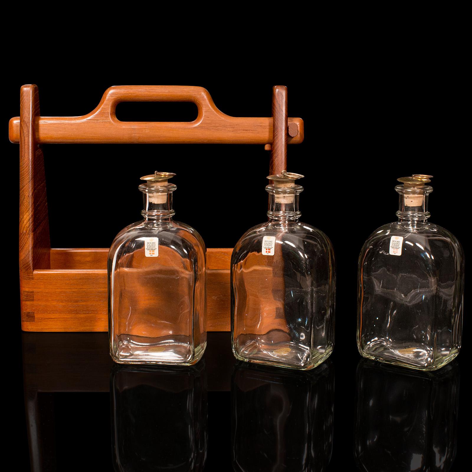 This is a vintage spirit Tantalus. A Danish, teak and glass bar caddy, dating to the mid 20th century, circa 1960.

Appealing Scandinavian craftsmanship, with fascinating form and function
Displays a desirable aged patina and excellent condition