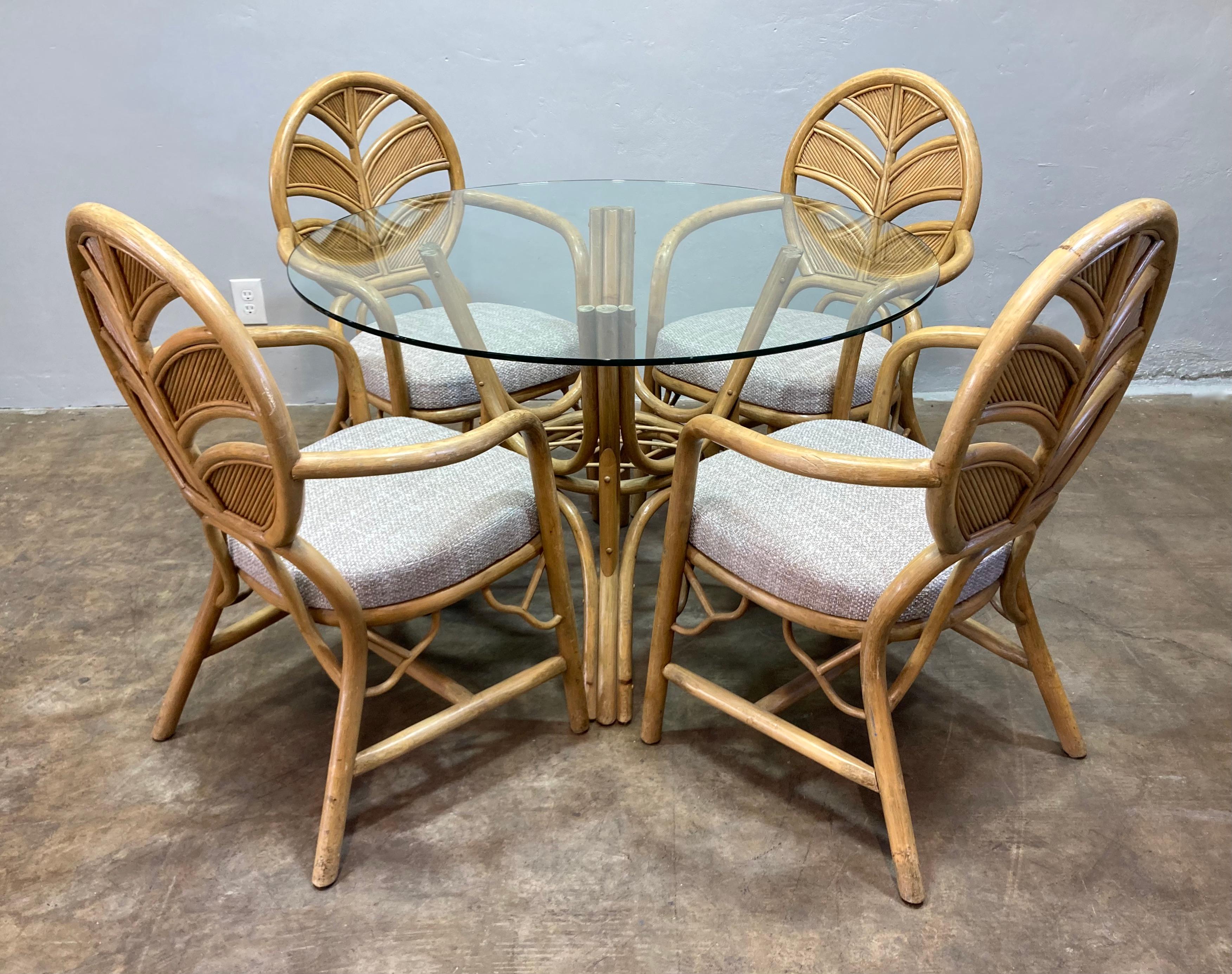 Ensemble de salle à manger vintage Split Reed entièrement intact, comprenant une base de table en bambou, un plateau en verre et quatre chaises récemment retapissées. Les dossiers des chaises sont conçus avec un motif de feuillage structurel et les