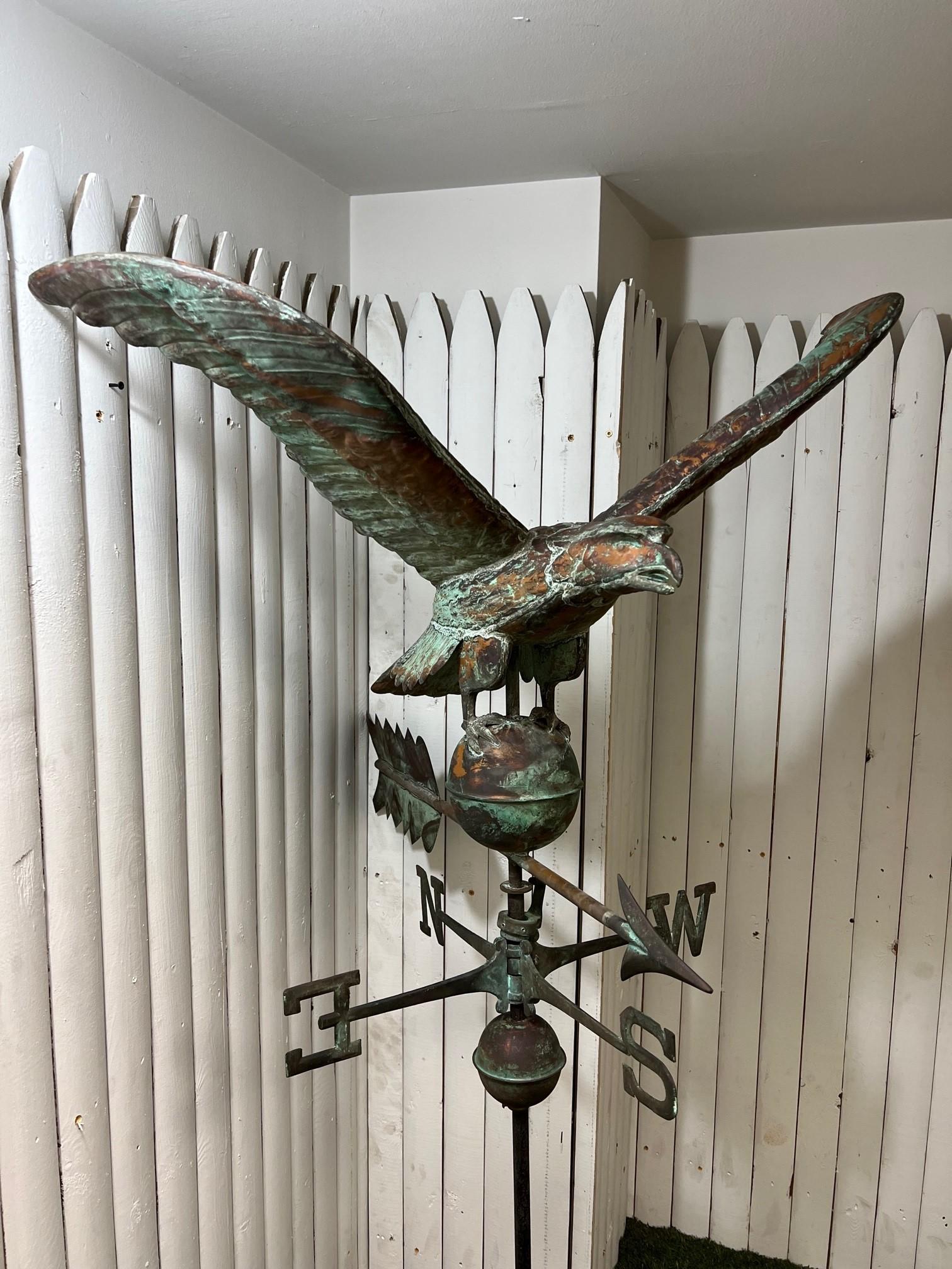 Vintage molded copper spread winged eagle weathervane with circular sphere, arrow and directionals on a iron rod. This weathervane was salvaged off a barn in Stamford Ct and has been in storage since 1987. It has a fine natural verdigris patina that
