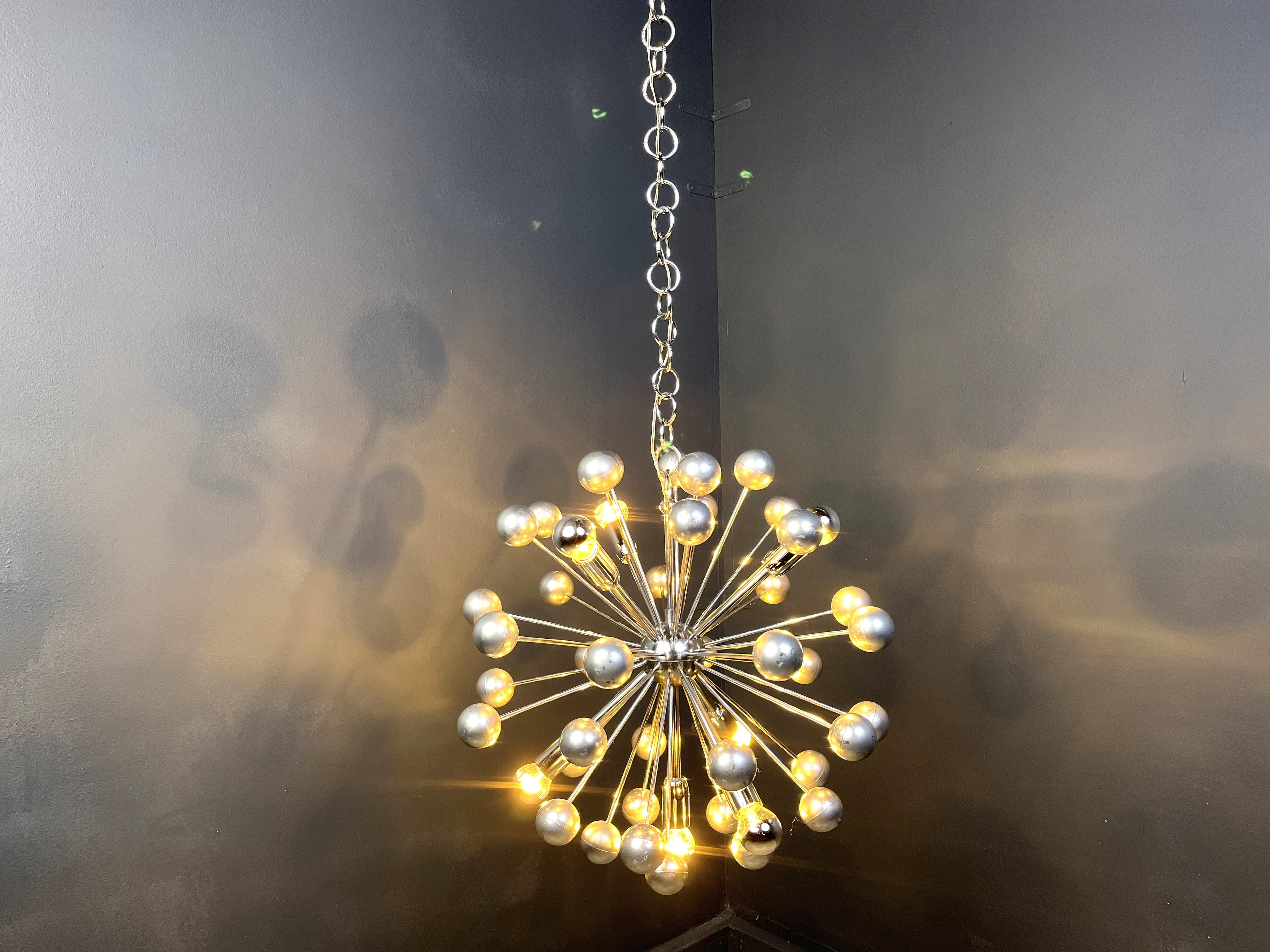 Mid century chrome sputnik chandelier with chromed plastic/metal parts.

The lamp emits a spectacular light.

Normal age related wear and tear. 

Tested and ready for use with regular E14 light bulbs. The chandelier is compatible for all