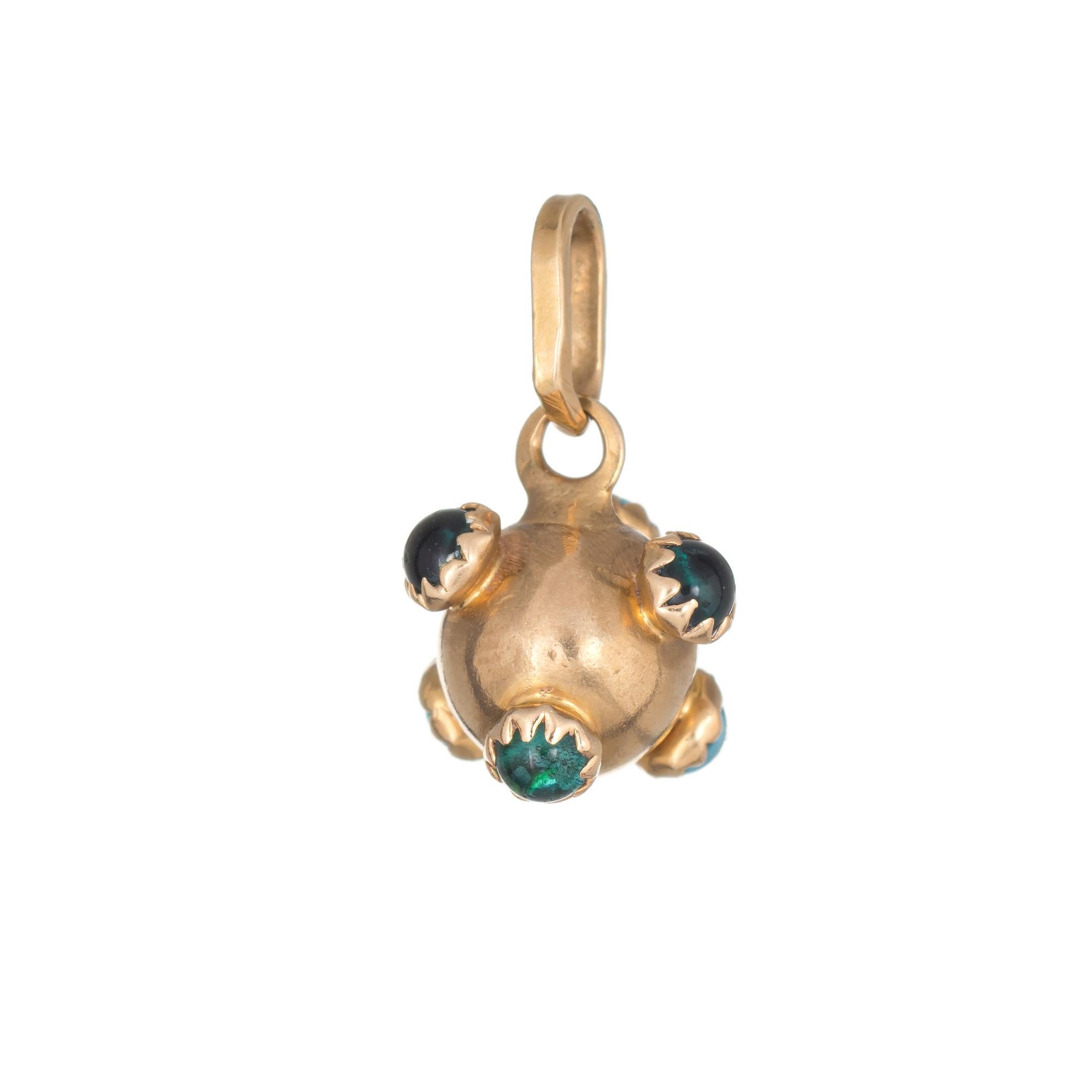 Ornate sputnik pendant (circa 1950s to 1960s) crafted in 18 karat yellow gold. 

Small 2mm green stones (synthetic) adorn the pendant. The stones are in excellent condition and free of cracks or chips.

The pendant measures 13mm (0.51 inches) and is