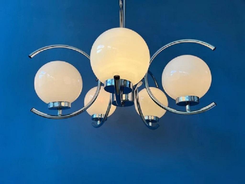 Vintage sputnik space age chandelier pendant light with 5 opaline glass shades. The chrome rings with the shades can be turned in any position desirable (up, down, left, ring). The lamp is pretty heavy and therefore requires a proper mounting. The