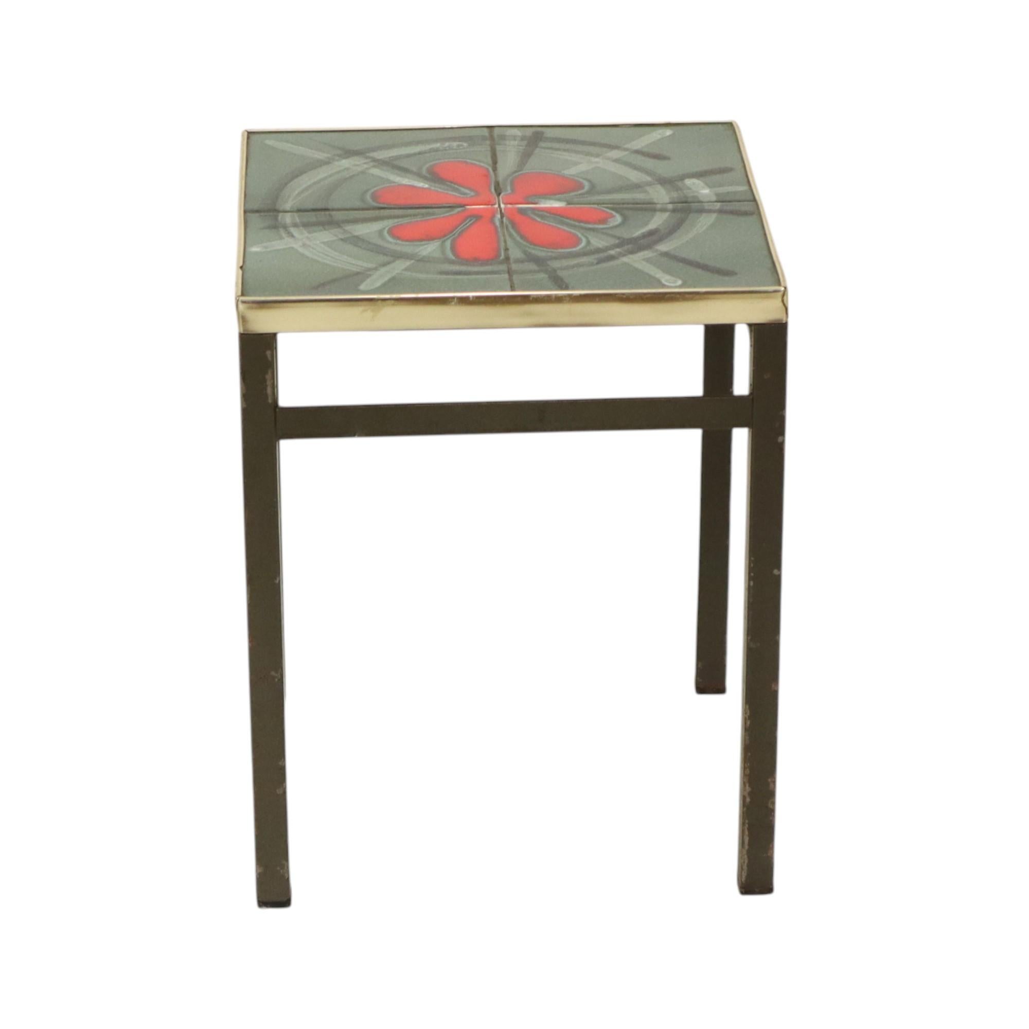 Tavolo o tavolino quadrato in ceramica d'epoca, noto anche come tavolo di piastrelle, il piano è un'opera d'arte composta da ceramica smaltata, intorno a una fascia di plastica color oro e a una base di metallo nero; questi tavoli erano molto