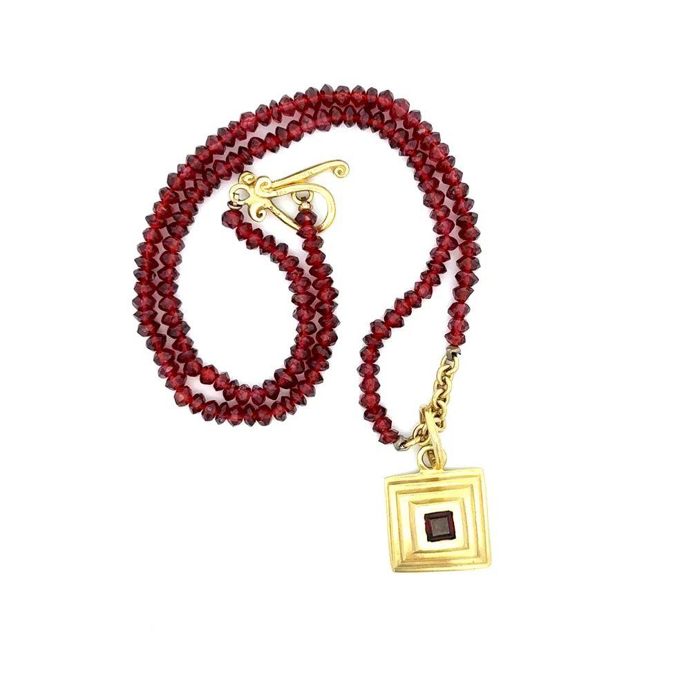 Semplicemente bello! Ciondolo quadrato in oro con granato finemente dettagliato, sospeso da una collana di perline a rondelle di granato con chiusura a gancio. Ciondolo realizzato a mano con montatura in oro giallo 18 carati. La collana misura circa