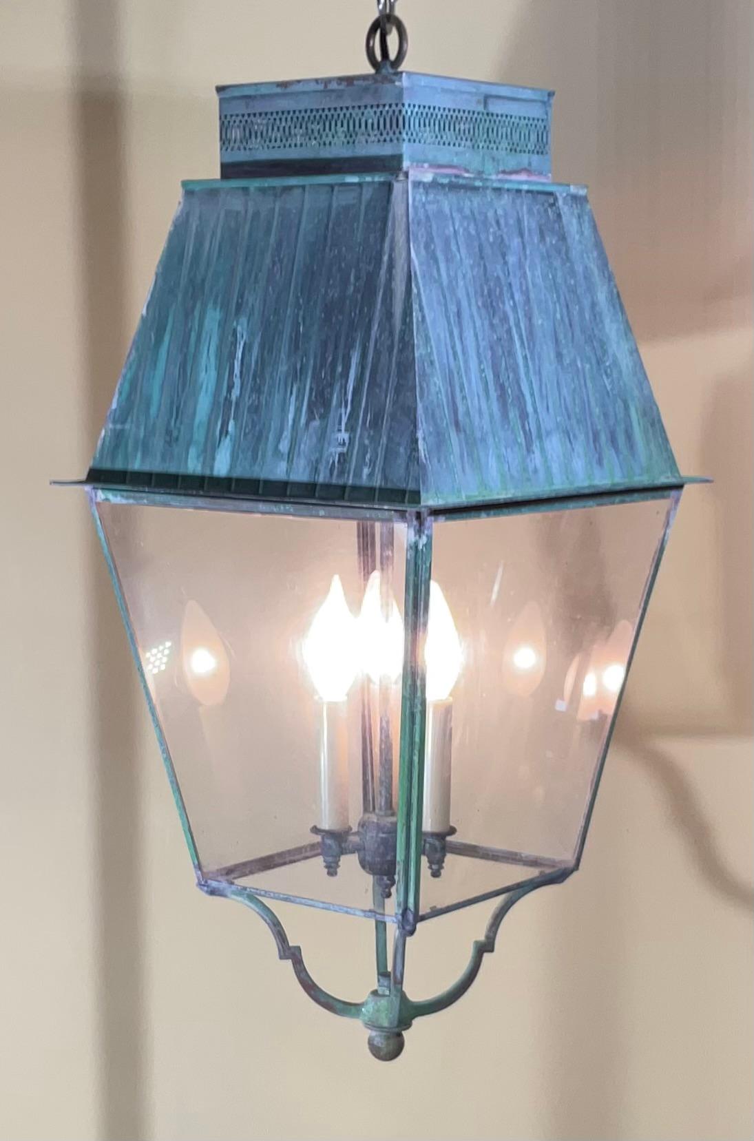 elegant vintage hanging lantern made of solid brass, with three 60/watt  lights 
Original clear acrylic sides.
Very nice patina 
New Canopy and chain included.

