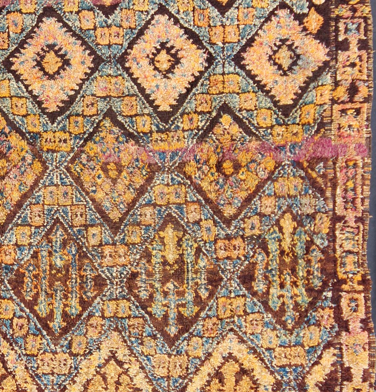 Measures: 7'9'' x 8'4''.

This piece is a thick and lush vintage tribal Moroccan carpet which originated from the northern Middle Atlas mountains. The weavers of the piece, people of the Berber tribe, are known to create very special deep pile