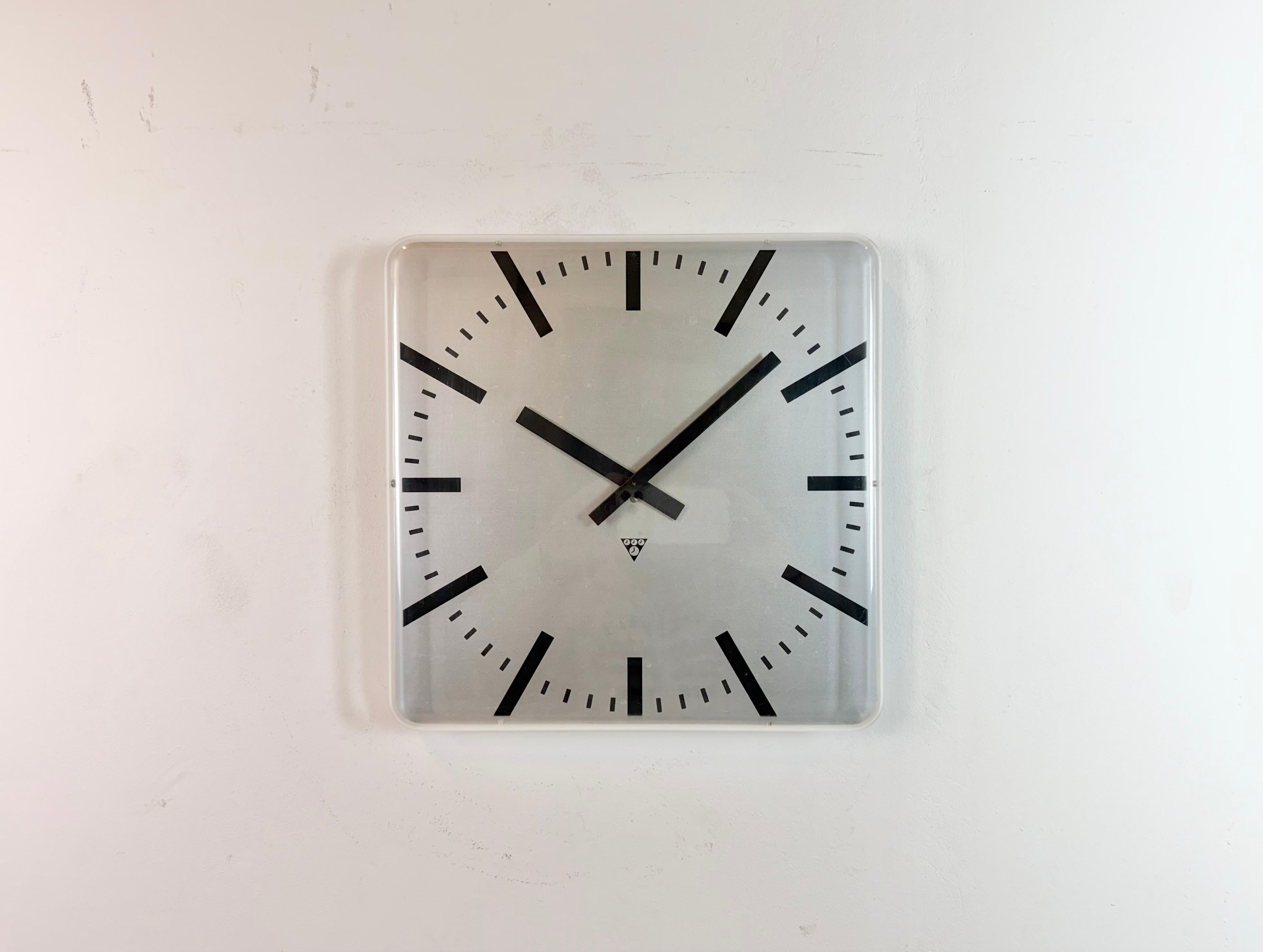 Industrielle Wanduhr, hergestellt von Pragotron in der ehemaligen Tschechoslowakei in den 1980er Jahren. Sie hat ein quadratisches Aluminiumzifferblatt und eine gewölbte Kunststoffabdeckung aus Klarglas. Das Stück wurde in ein batteriebetriebenes