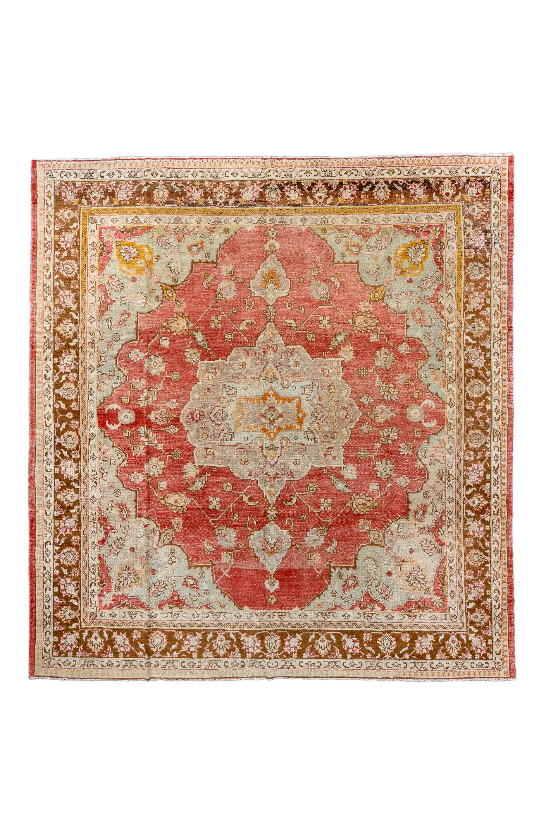 Better woven than most Oushaks, this room size shows a twelve point medallion with ecru sub-medallion, on an abrashed rust-red field, with an even supporting cast of palmettes, and two pointed flame-like pendants.  Red palmette border. A versatile