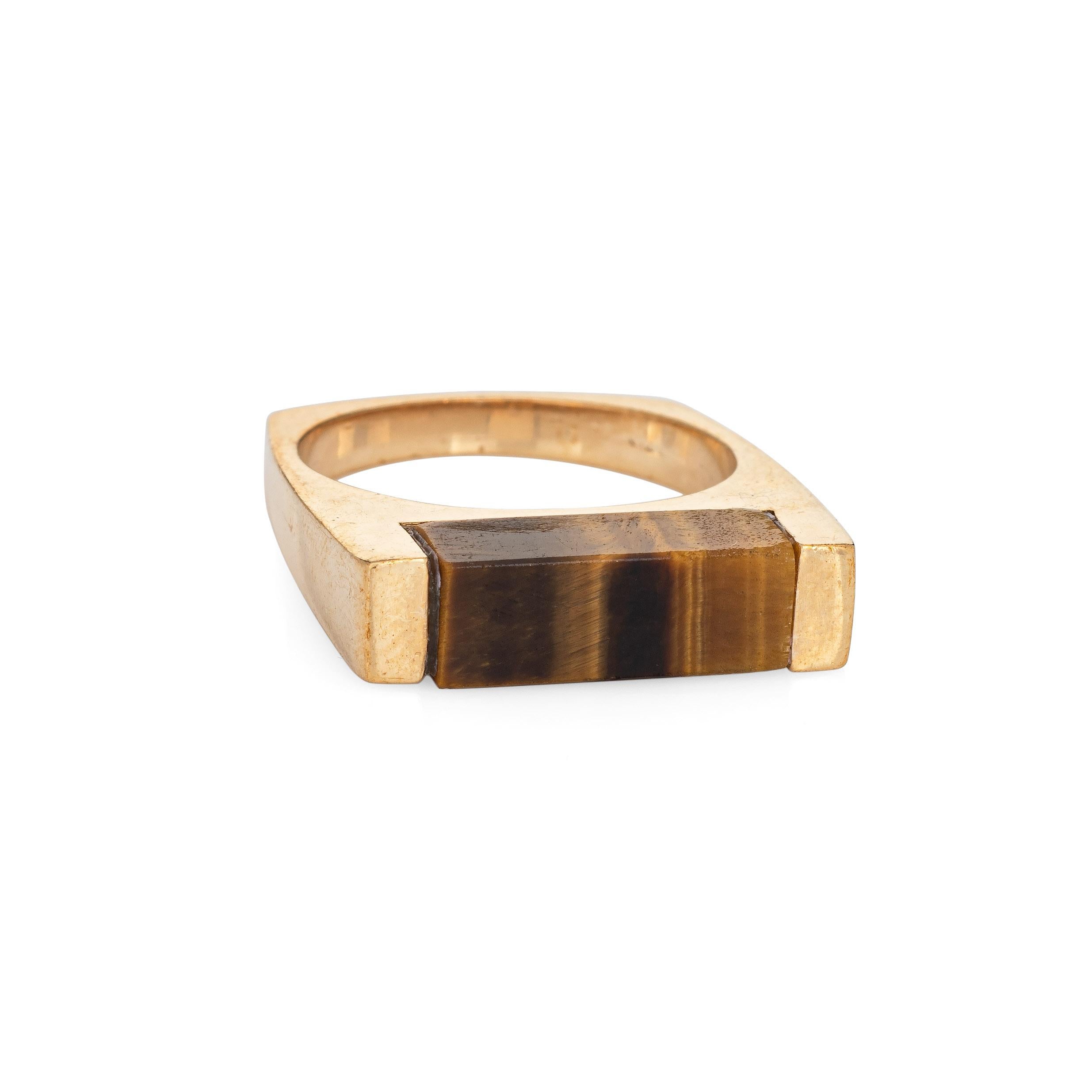Stylish vintage square stacking ring (circa 1970s to 1980s) crafted in 14 karat yellow gold. 
The band is inlaid with tigers eye measuring 5mm wide (few tiny nibbles to the tigers eye visible under a 10x loupe).

The striking square ring features