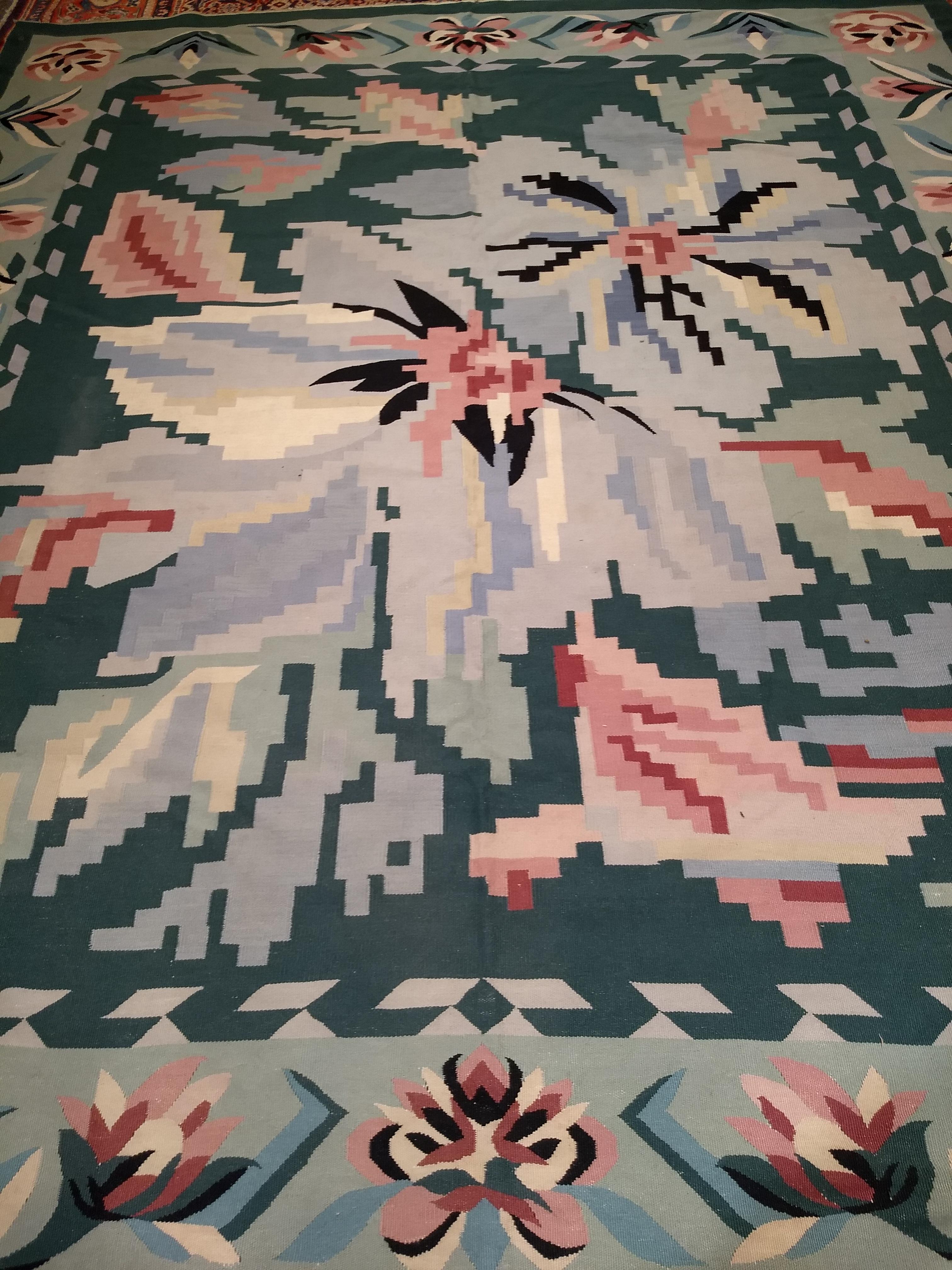 Vintage hand-woven floral dhurrie kilim in a near square room size with a beautiful combination of mid-century modern pastel colors of green, ivory, pink, and pale blue.  This Floral Kilim has a large flower design covering the main field and a