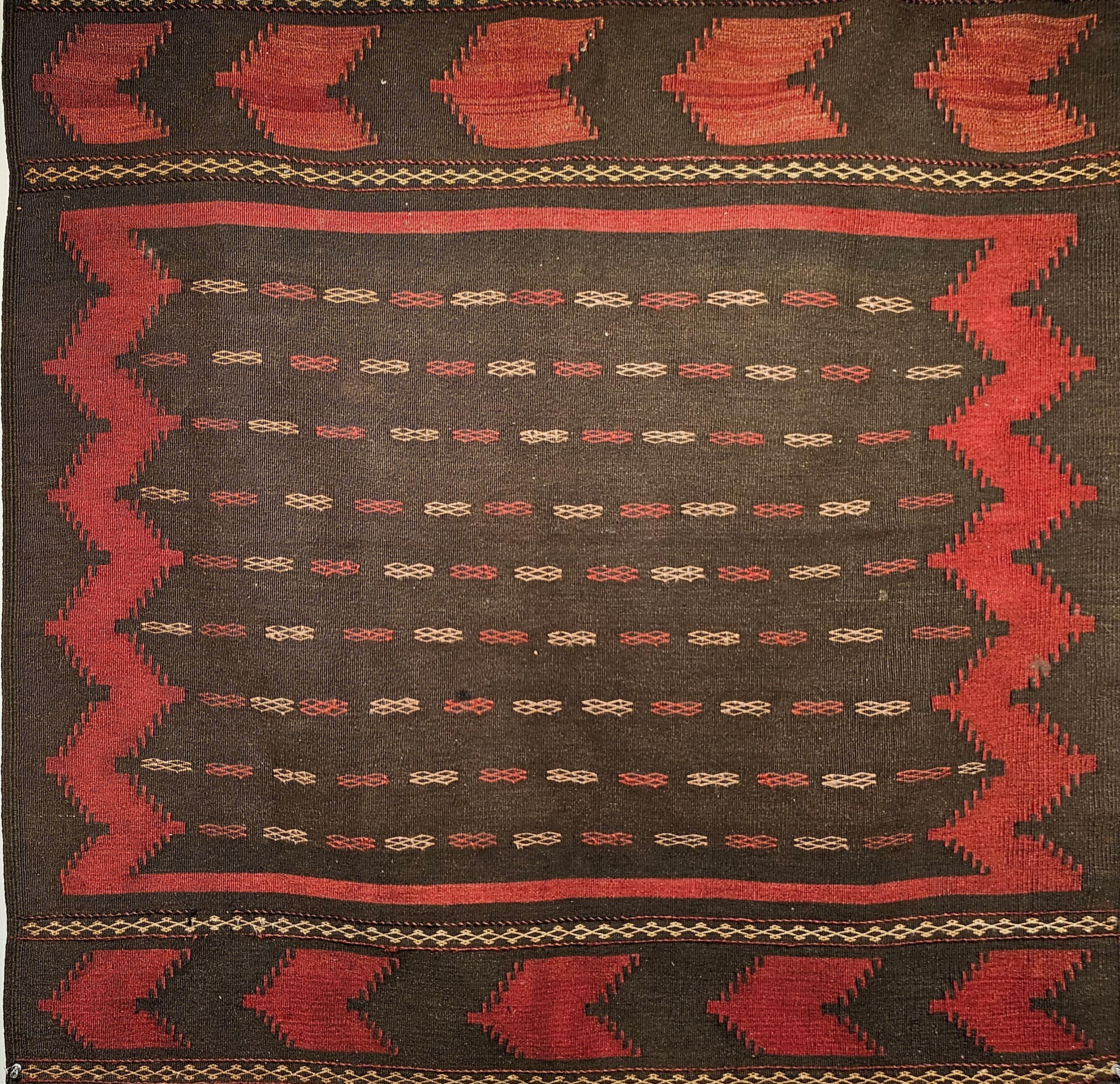 Este kilim tribal baluch persa de principios del siglo XX, excepcionalmente raro, es una pieza muy coleccionable de auténtico arte tribal. Tejido a mano por las tribus baluch del sudeste de Persia, este deseable kilim de formato cuadrado se