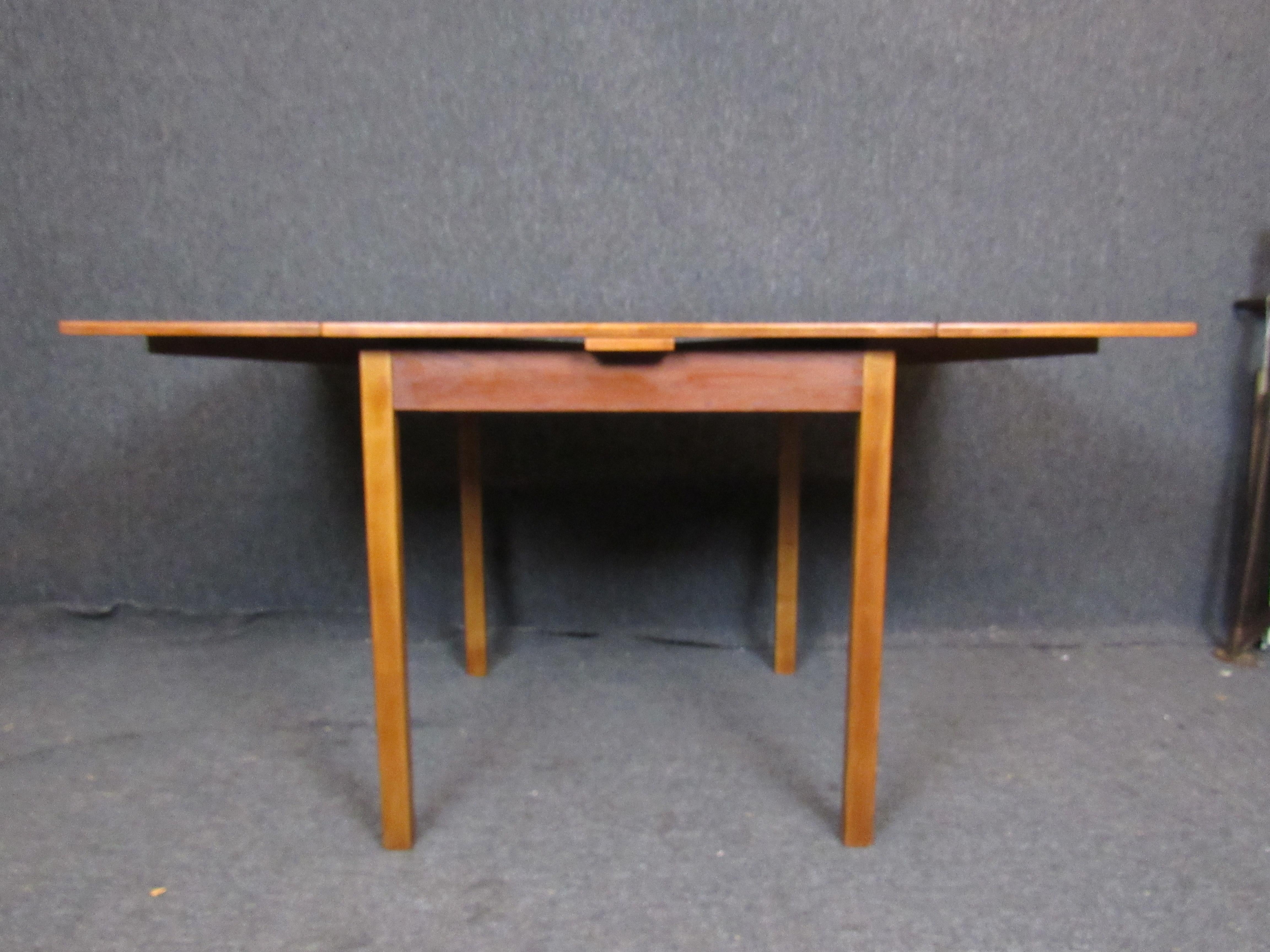 Charming little teak dining table absolutely perfect for a city apartment or any other small spaces. Perfect for a party of four with the leaves stored away, both ends pull out to reveal an ample 56