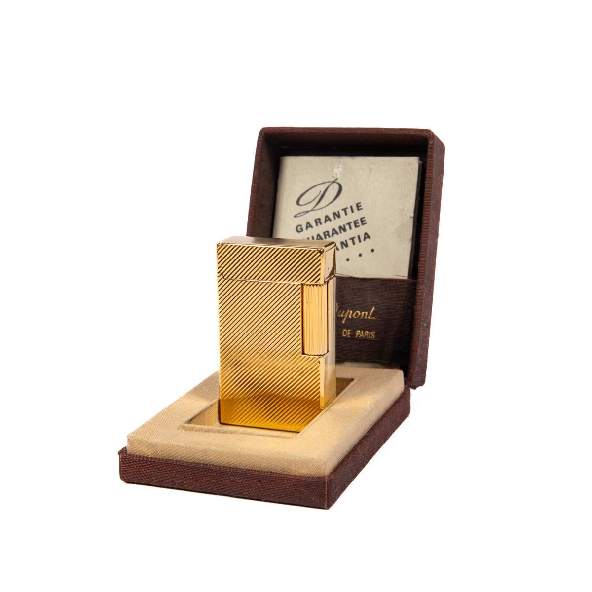 Vintage Gold Plated Linge 1 BR ST Dupont Lighter 1980s In Box

The iconic S.T. Dupont name is known for quality, well-made cigarette lighters and other luxury implements. The company’s origin can be traced to Simon Tissot-Dupont opening his workshop
