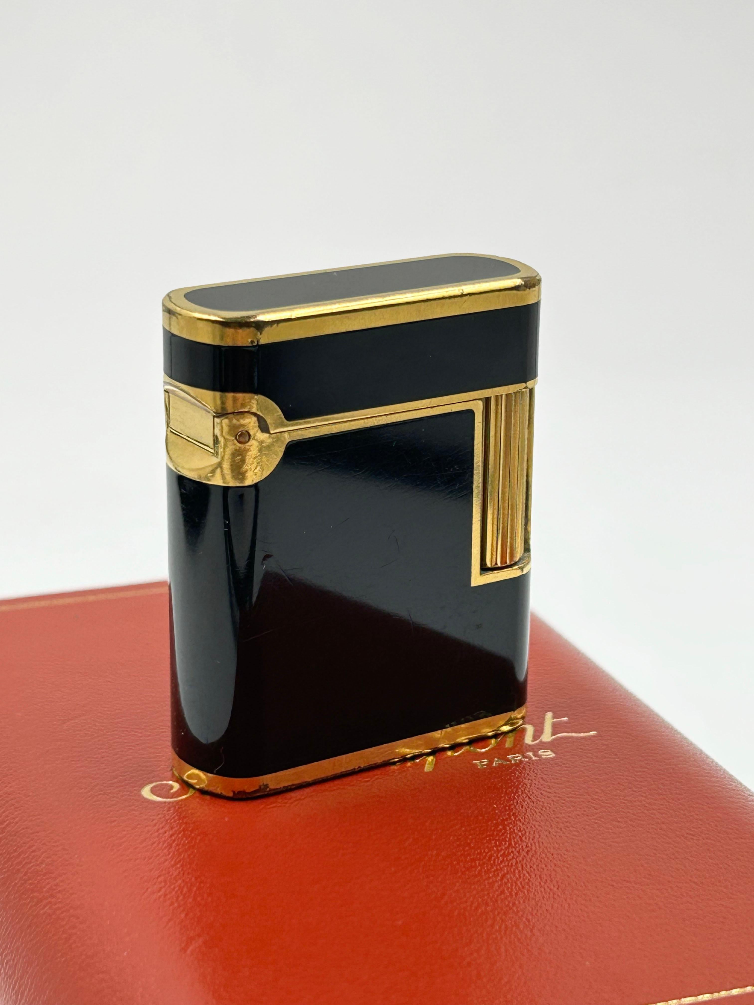 Vintage St. Dupont Soubreny Feuerzeug von 1990
Dieses Vintage-Feuerzeug von St. Dupont Soubreny stammt aus dem Jahr 1990 und zeichnet sich durch ein elegantes zweifarbiges Design aus schwarzem Chinalack und Goldplattierung aus. Im Laufe der Jahre