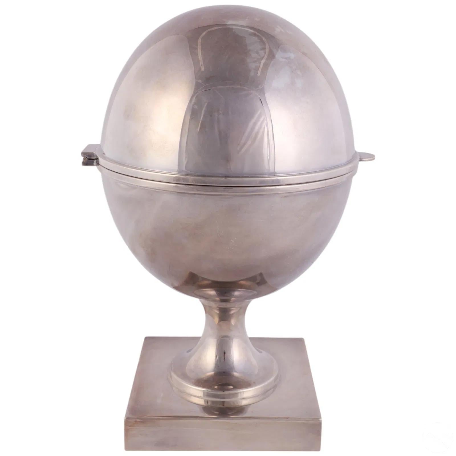 Vintage silver plate caviar server by St. James of vertical ovoid form on a tapered pedestal rising from a square foot. The egg form container hinged at the center reveling a removable insert above the ice chamber.