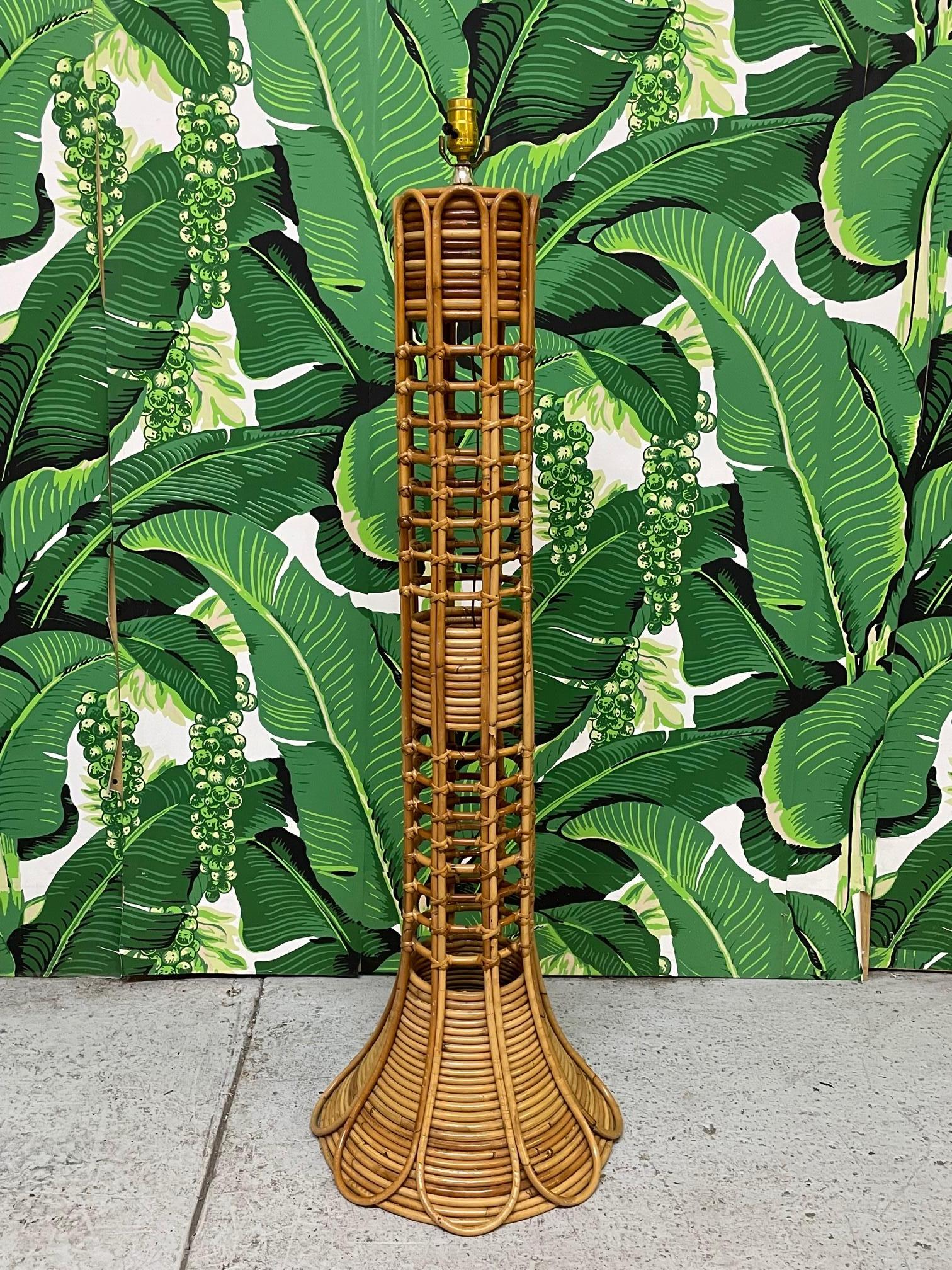 Vintage rattan floor lamp features stacked rattan base and unique fretwork. Top covered in woven wicker. Good condition with minor imperfections consistent with age.

 