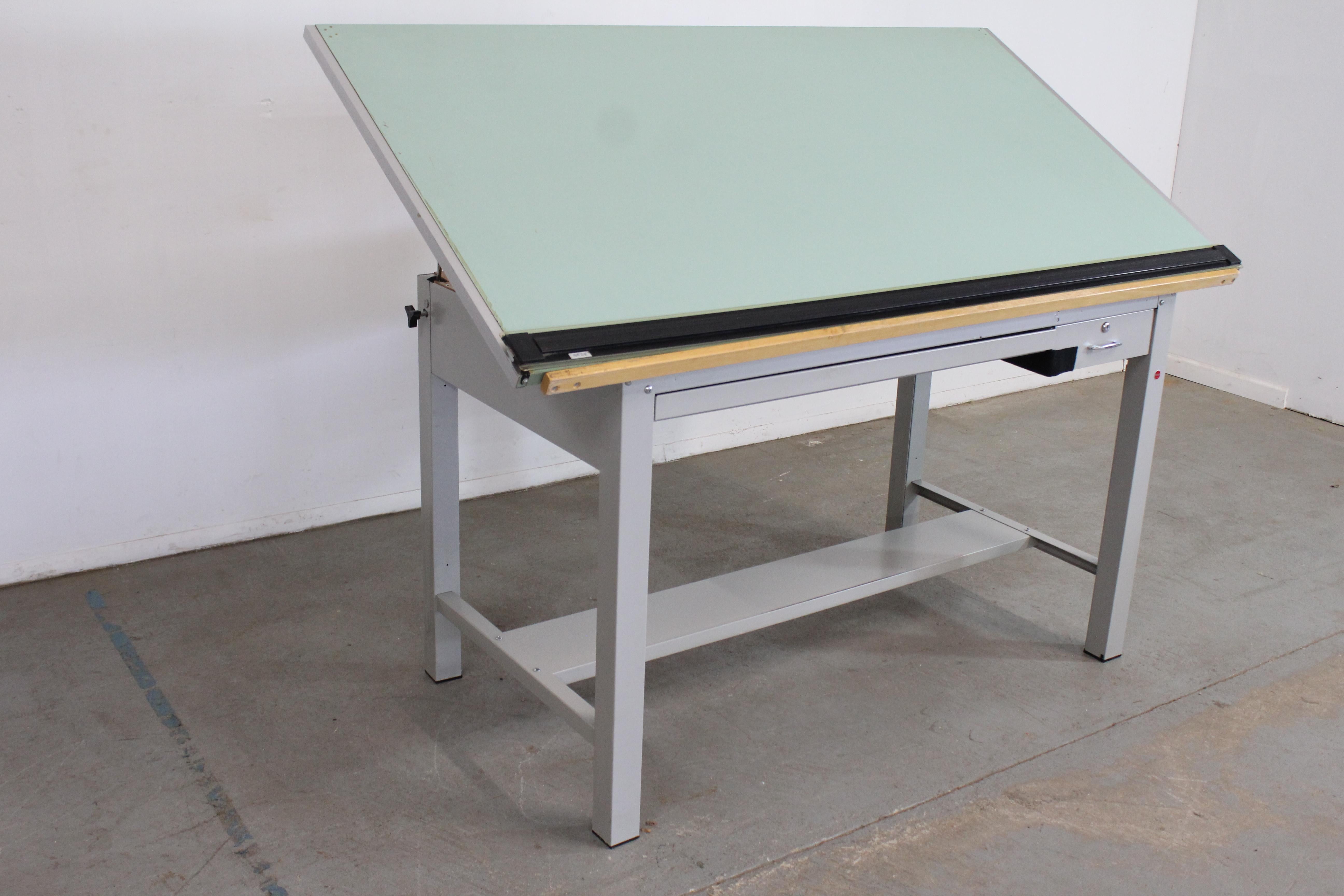 Vintage Industrial adjustable drafting table desk

Offered is a vintage, adjustable drafting table made of wood (top) with steel base and hardware. The table top and height are adjustable (please message us for more measurements). The table