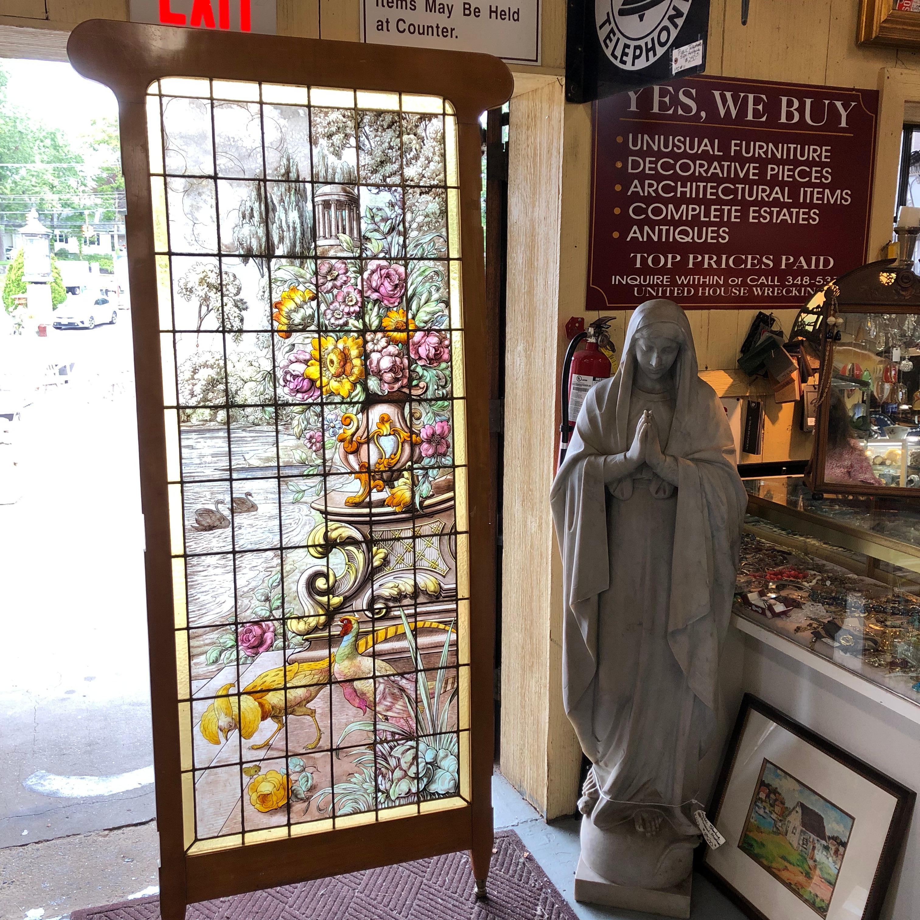 Beautiful vintage stained glass window. Perhaps one of a pair? In a wood frame as a room divider. Hand painted design of garden with flowers and birds of paradise. No signature found. Has three loose places where lead needs repair. Size of stained