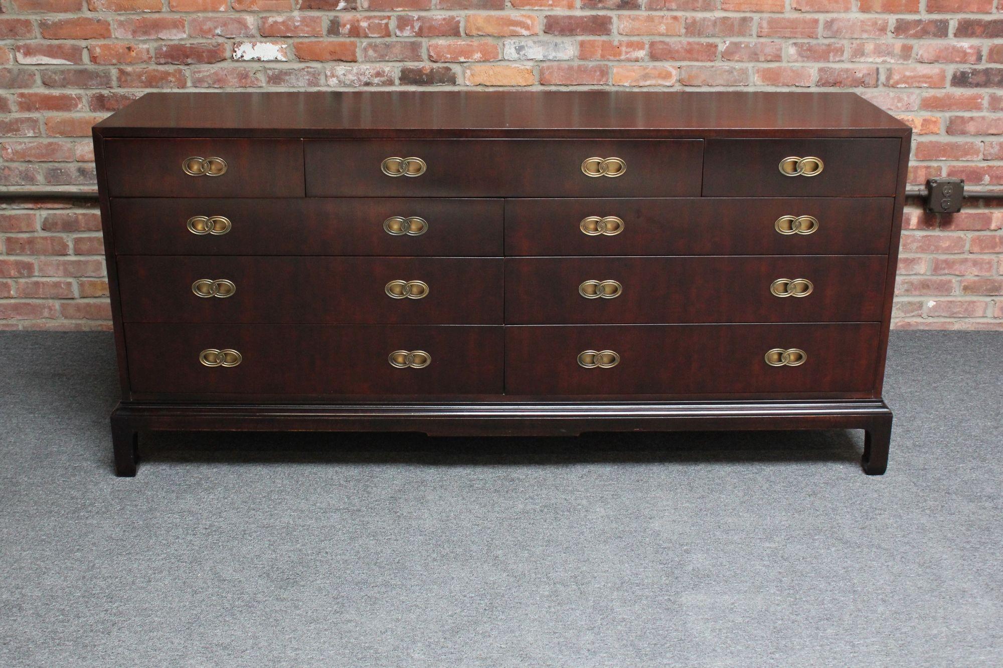 Luxurious Hendredon nine-drawer chest of drawers/dresser (ca. 1970s, USA). Composed of a richly stained satinwood chest featuring seven long and two short drawers with interlocking brass oval 
