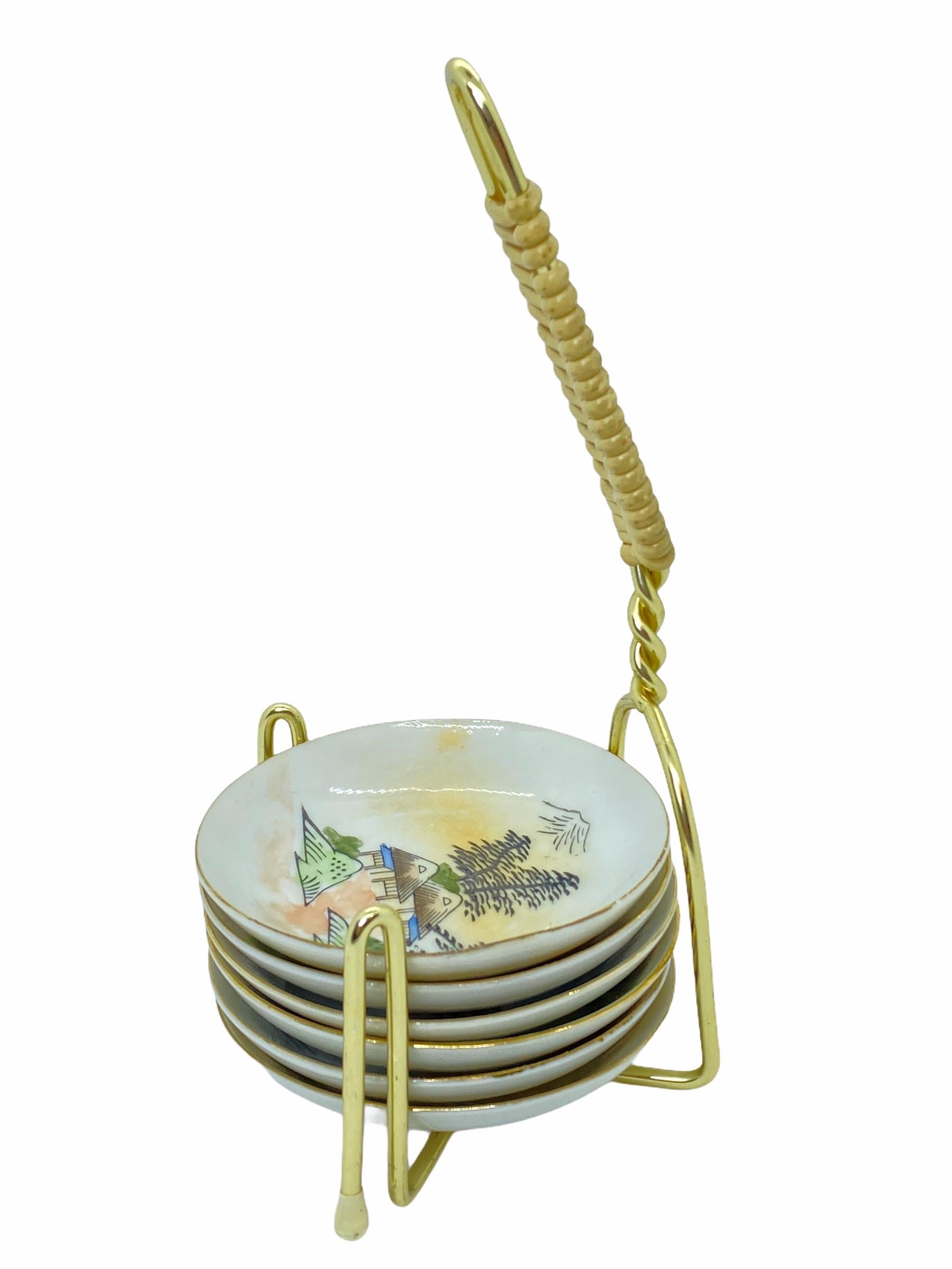 This lovely piece is typical, 1950s. Six little plates in Japanese or Chinese design for nuts or finger food and a golden metal stand. The little plates are approximate 3 3/8