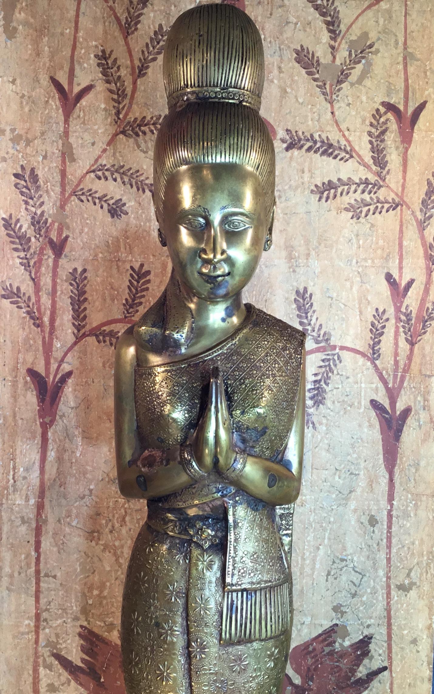 Elegant statue made of bronze, beautiful facial expression, hands pointed forward in grace and goodwill. Exceptional dress with vivid stars like repetitive motif all around. One of a kind object of art for display.