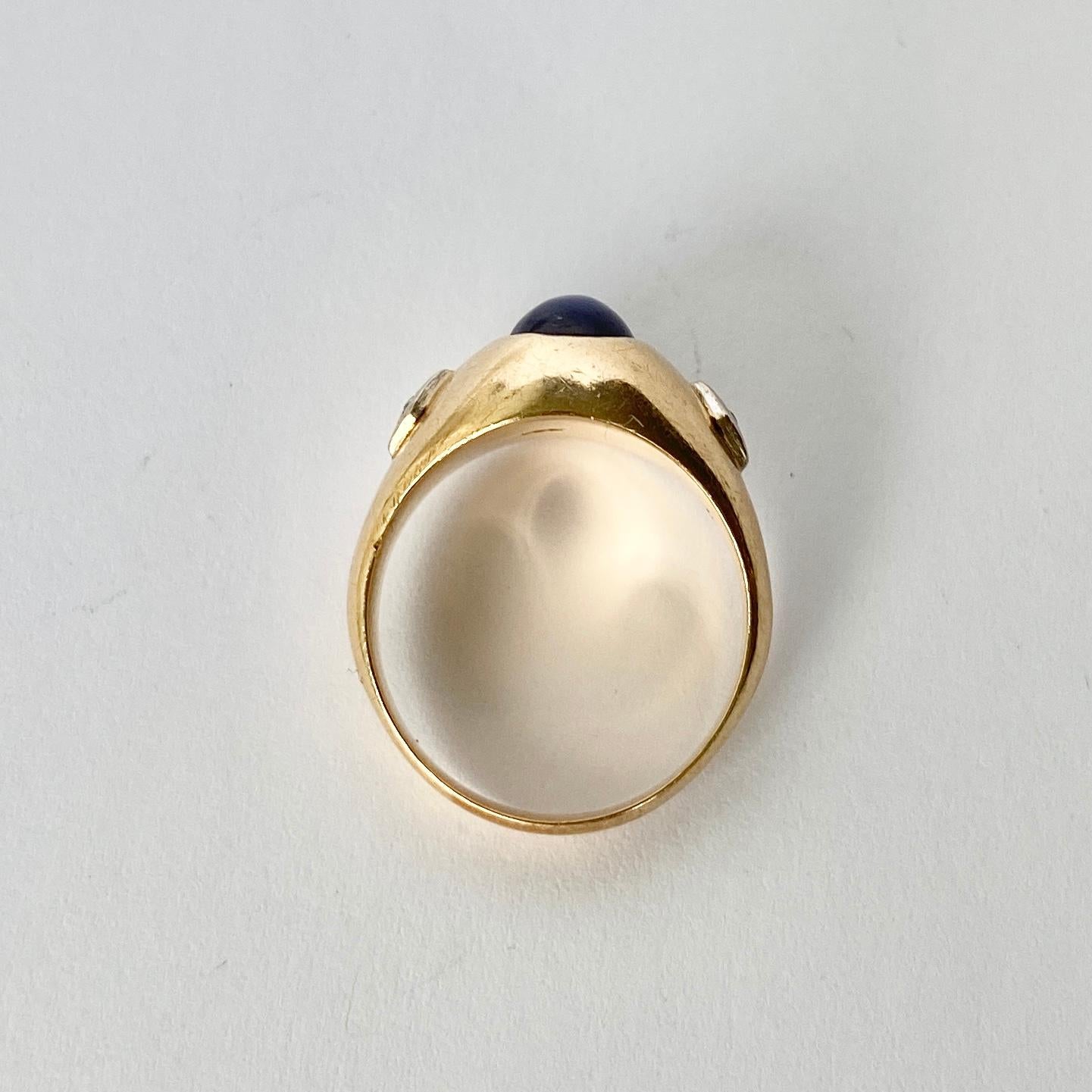 Dieses atemberaubende, klobige Band aus 14 Karat Gold trägt einen faszinierenden Sternsaphir mit Diamanten an beiden Seiten. Die Diamanten sind in Platin gefasst. Wenn sich der Ring bewegt, folgt der Stern. 

Ringgröße: K 1/2 oder 5 1/2 
Breite des