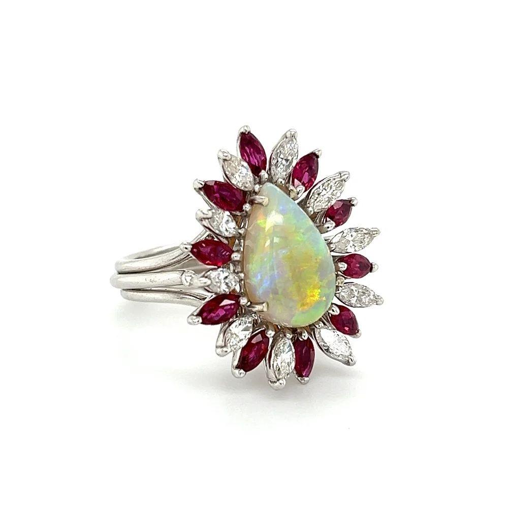 Simply Beautiful! Finely detailed and Elegant Mid Century Modern Platinum Statement Cocktail Ring. Centering a Luminous 3.00 Carat Pear-cut Opal, surrounded by 0.95tcw of Glittering Marquise Diamonds and 1.40tcw of Regal Marquise Rubies. Hand