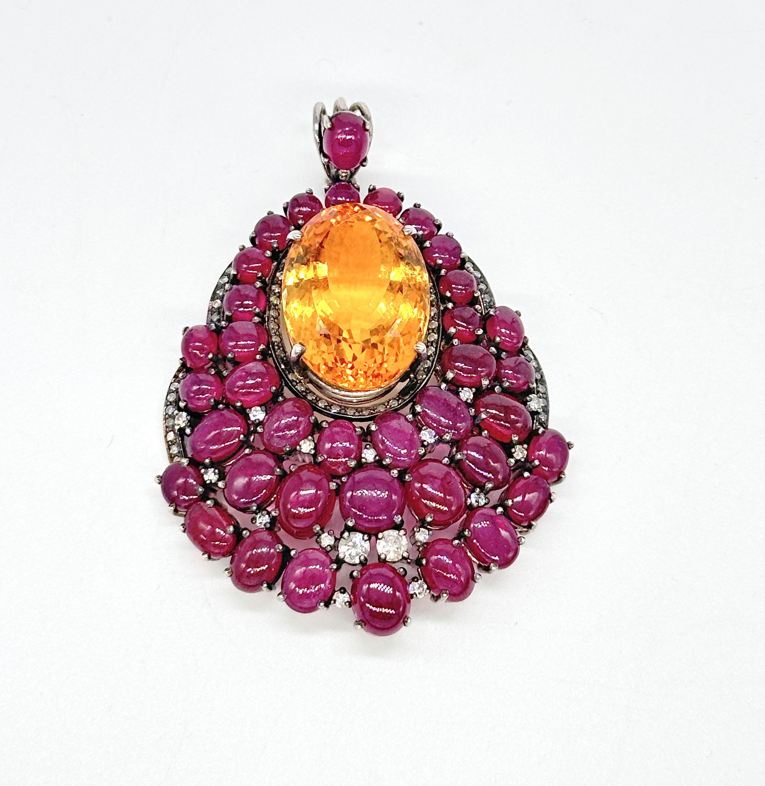Ce magnifique pendentif est composé d'argent oxydé avec de rares rubis cabochons naturels et de la citrine naturelle. L'aspect du pendentif est rehaussé par les véritables diamants de taille brillant qui y sont soigneusement sertis. Il est composé
