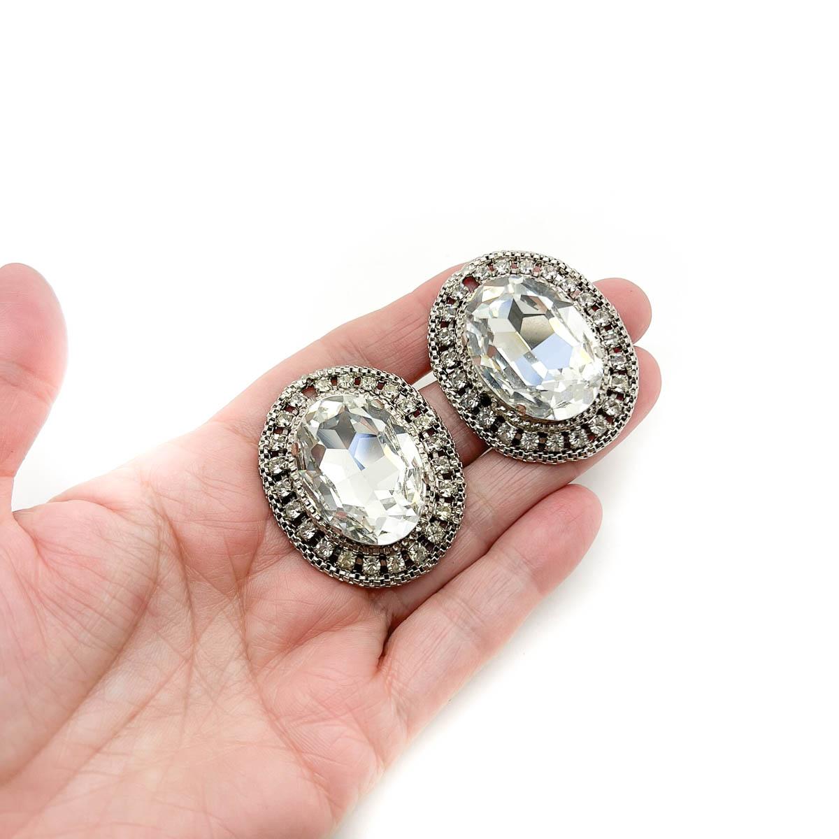 A striking Pair of Vintage Headlamp Crystal Earrings. Featuring a huge oval crystal within a gallery of chatons and chain. 80s extravagance at its best. Sparkle on every occasion.
An unsigned beauty. A rare treasure. Just because a jewel doesn’t