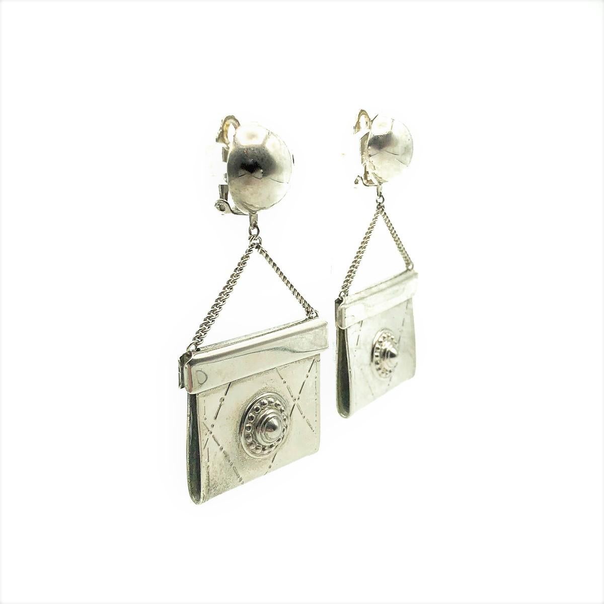 Pendientes de bolso vintage. Realizada en metal tono peltre (metal tono plata oscurecido). Con un colgante tridimensional estilo bolso que cae de un botón en la parte superior. En muy buen estado vintage, sin daños ni reparaciones, aprox. 7,5 cm.