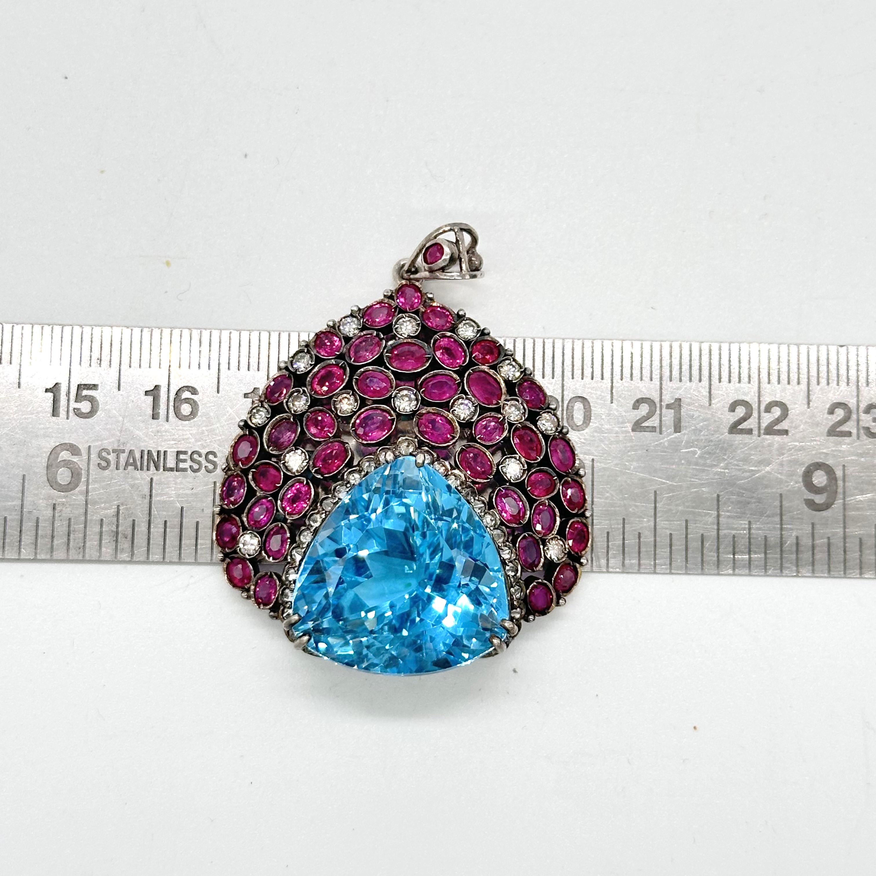 Questo splendido ciondolo è realizzato in argento ossidato con topazio blu naturale e rubini naturali. L'aspetto del ciondolo è impreziosito dai veri diamanti taglio brillante che vi sono accuratamente incastonati. È composto da argento sterling con