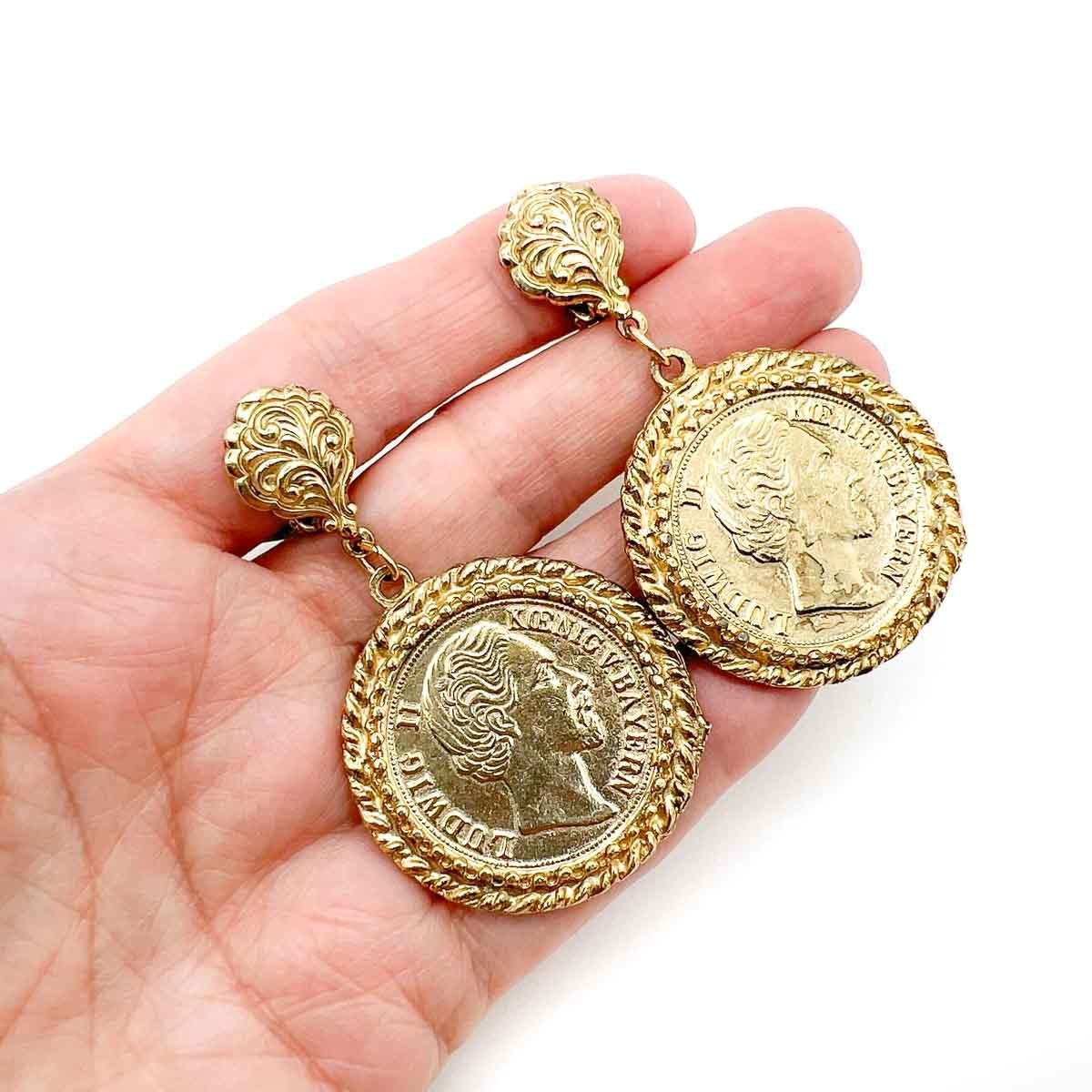 Ein fabelhaftes Paar Vintage Statement Coin Earrings. Glänzende Goldplatte und ein fabelhaft gestalteter doppelter Münztropfen. Völlig zeitlos mit einem gewissen Etwas.
Eine unsignierte Schönheit. Ein seltener Schatz. Nur weil ein Schmuckstück nicht