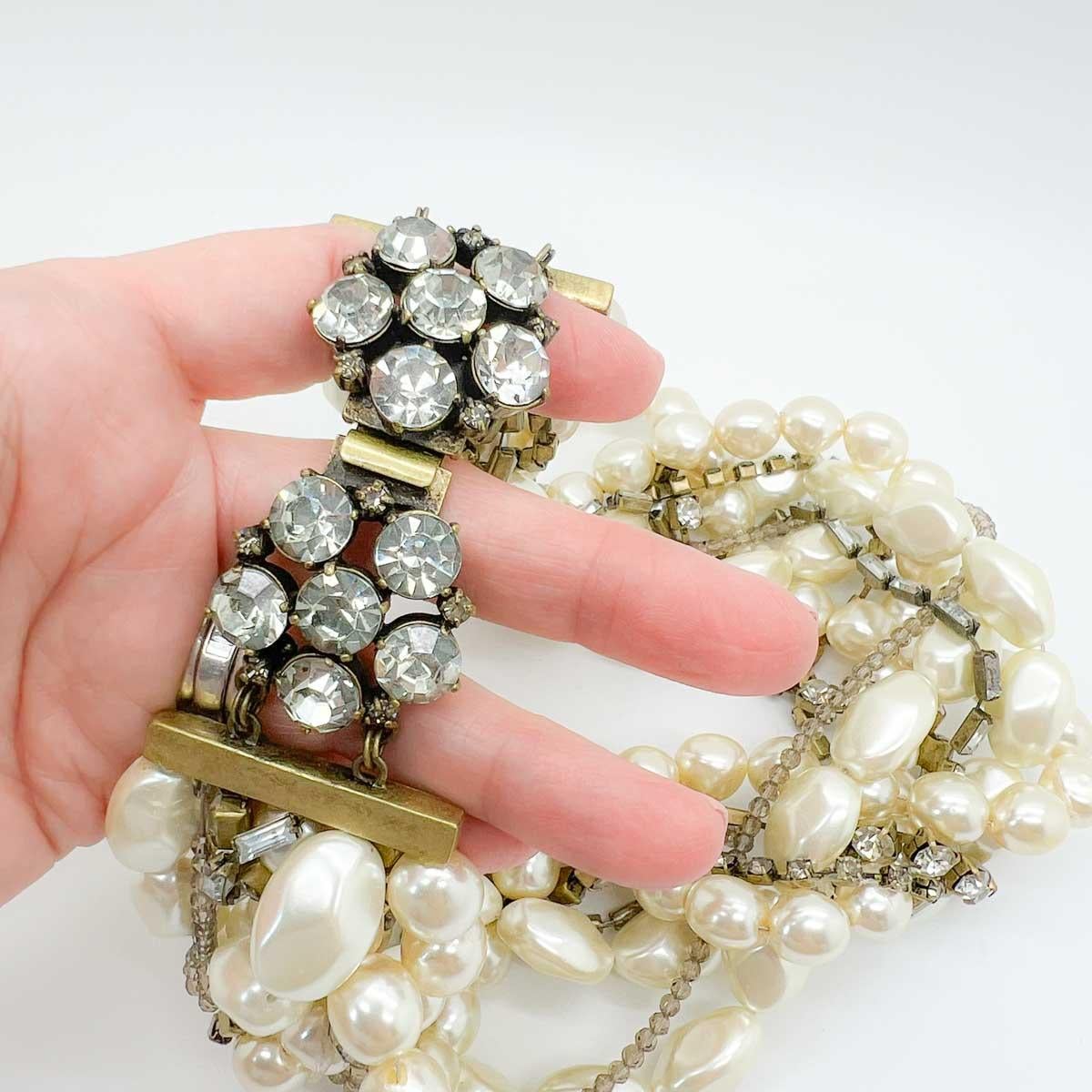 Una straordinaria dichiarazione d'epoca con cristalli di perle. File di pesanti perle di vetro si intrecciano con perline di cristallo e strass di fantasia per un accessorio mozzafiato. Alza la posta in gioco combinando un'eleganza senza tempo con