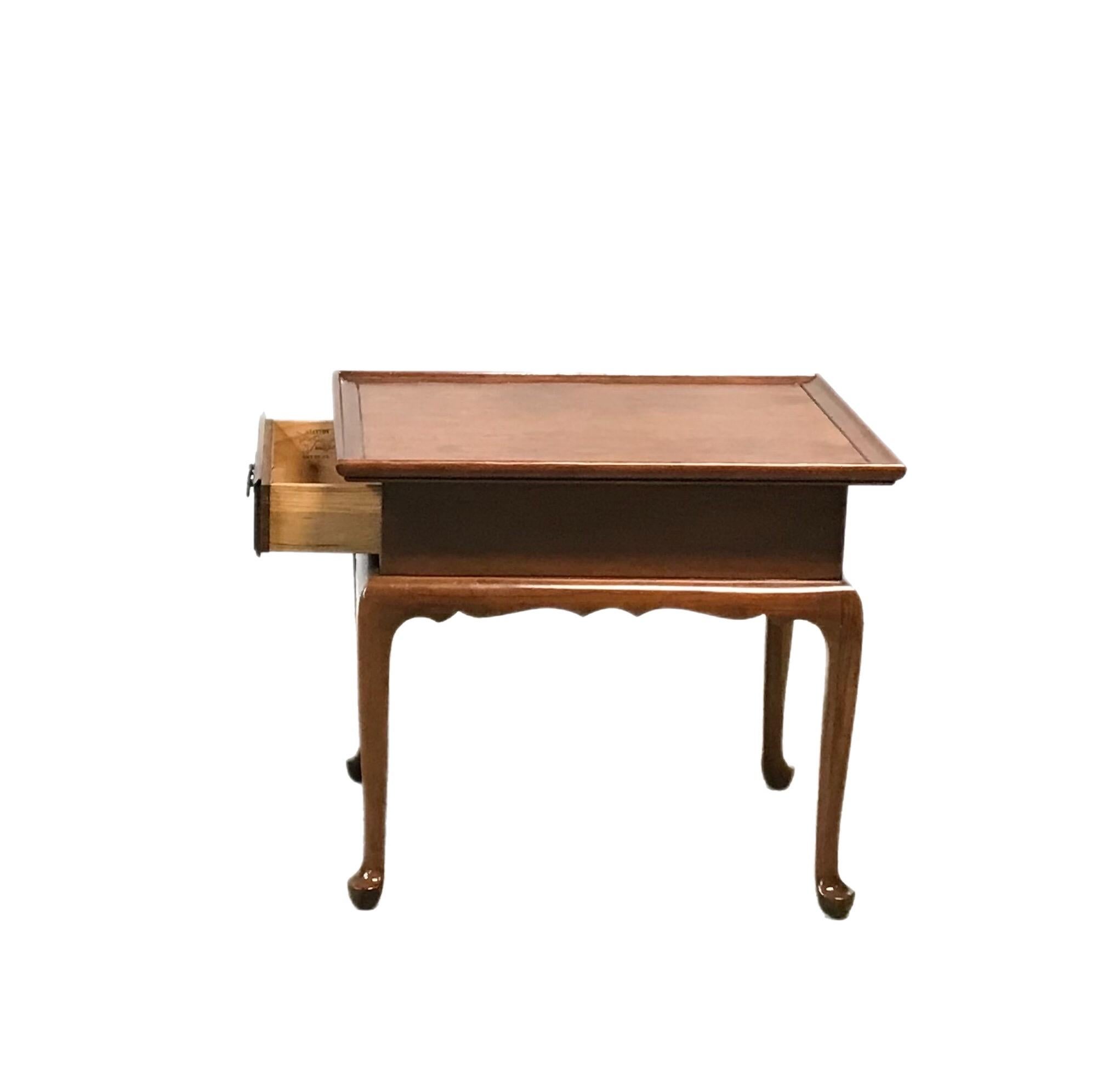 Vintage Cherry Statton Manufacture End Table. This piece presents with a single front drawer with brass batwing pull. The cabriole legs are accented by the scalloped skirt.