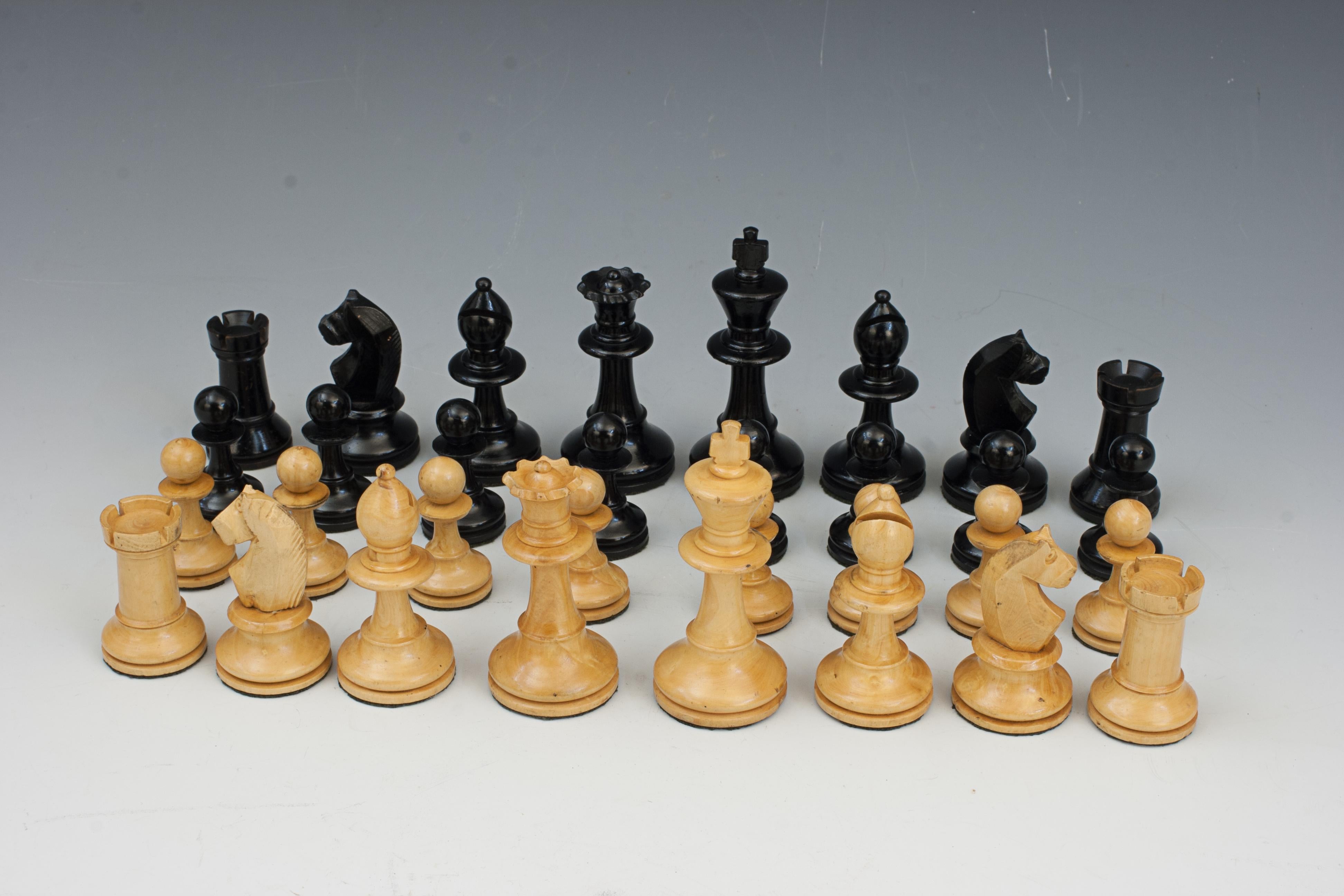 Antike Schachfiguren im Staunton-Stil.
Ein Schachspiel im Staunton-Stil mit hölzernen Schachfiguren mit breiten, gedrehten Sockeln für zusätzliche Stabilität, und die Unterseite jeder Figur ist mit Filz bedeckt, damit die Figuren leichter über das