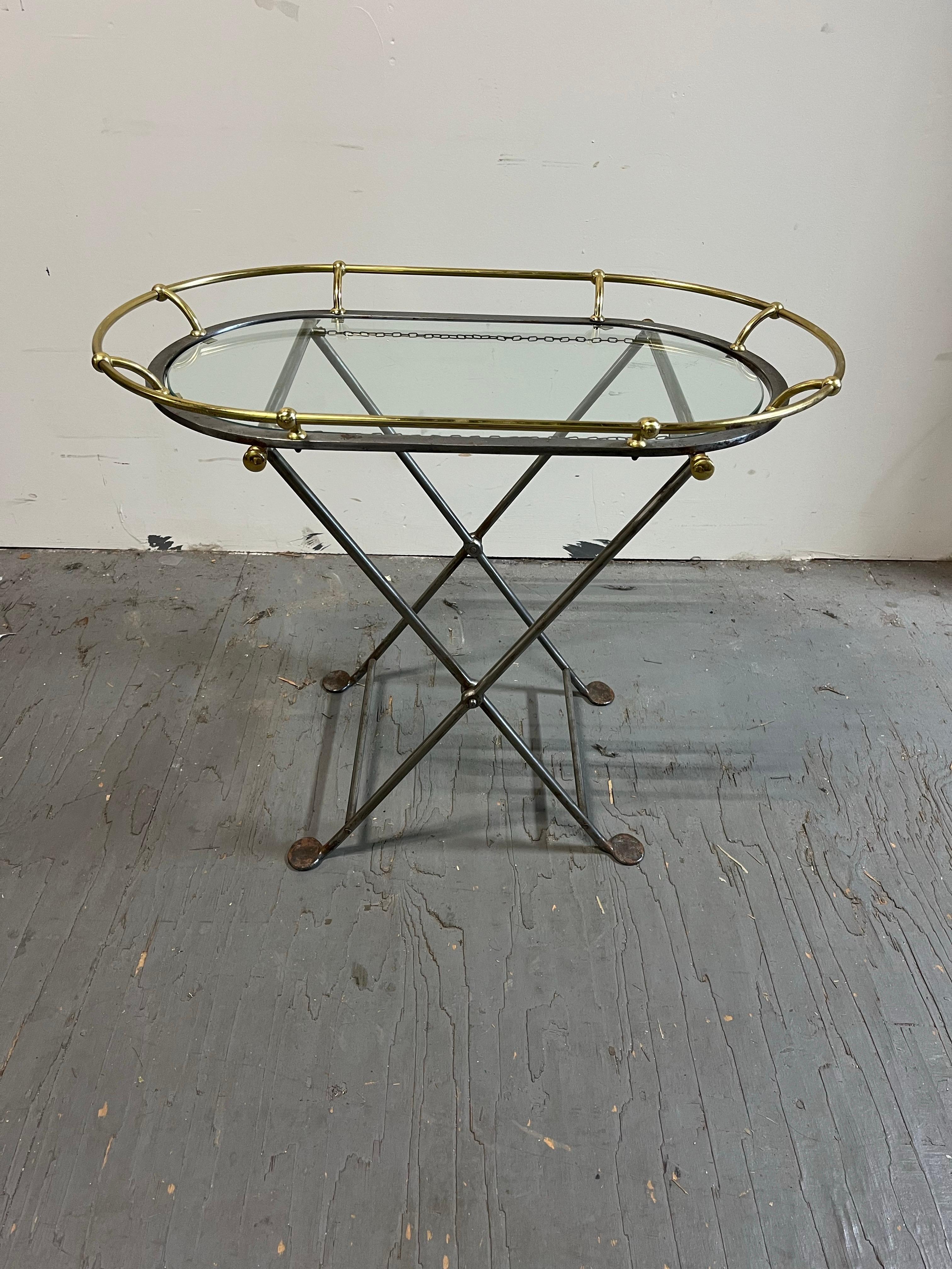Dieser elegante Butler-Tisch im Vintage-Stil verfügt über eine abnehmbare Glasplatte mit einem messingfarbenen Metallrahmen, der sich perfekt zum Servieren oder Ausstellen eignet. Man glaubt, dass er Franzose ist. Der faltbare Metallfuß ermöglicht