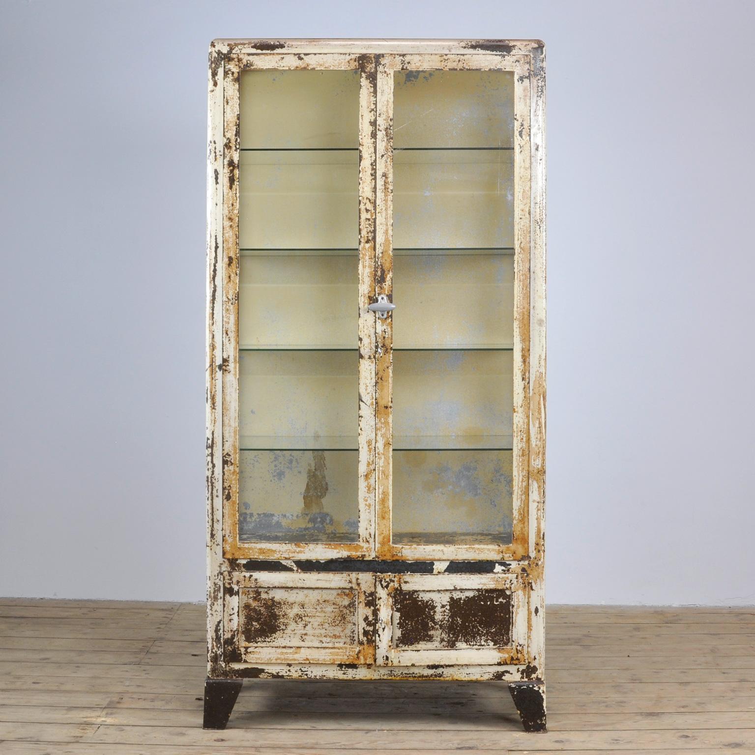 Medicinal cabinet from the 1930s with beautiful distressed paint. With properly working locks / keys. Treated against rust.