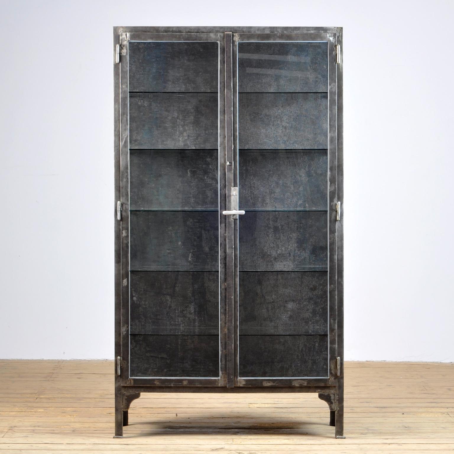 This medical cabinet was produced in the 1940s in Hungary. The cabinet is made from thick iron and glass. With the original lock and handle. The cabinet has been stripped from its paint, polished and treated for rust. It features five glass shelves.