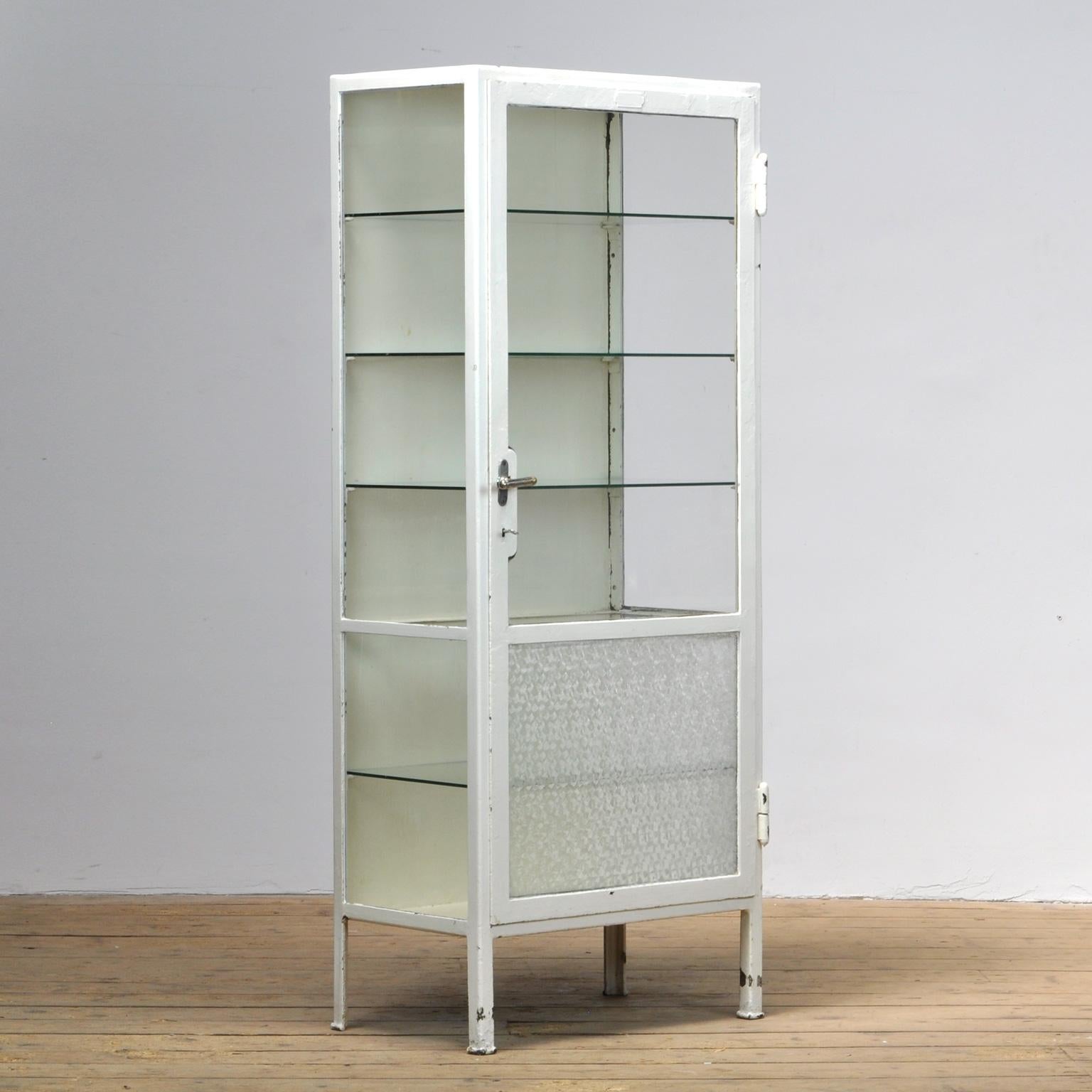 This medicine cabinet was produced in the 1930s in Hungary. The cabinet is made from thick steel and glass. It features five (new) glass shelves.