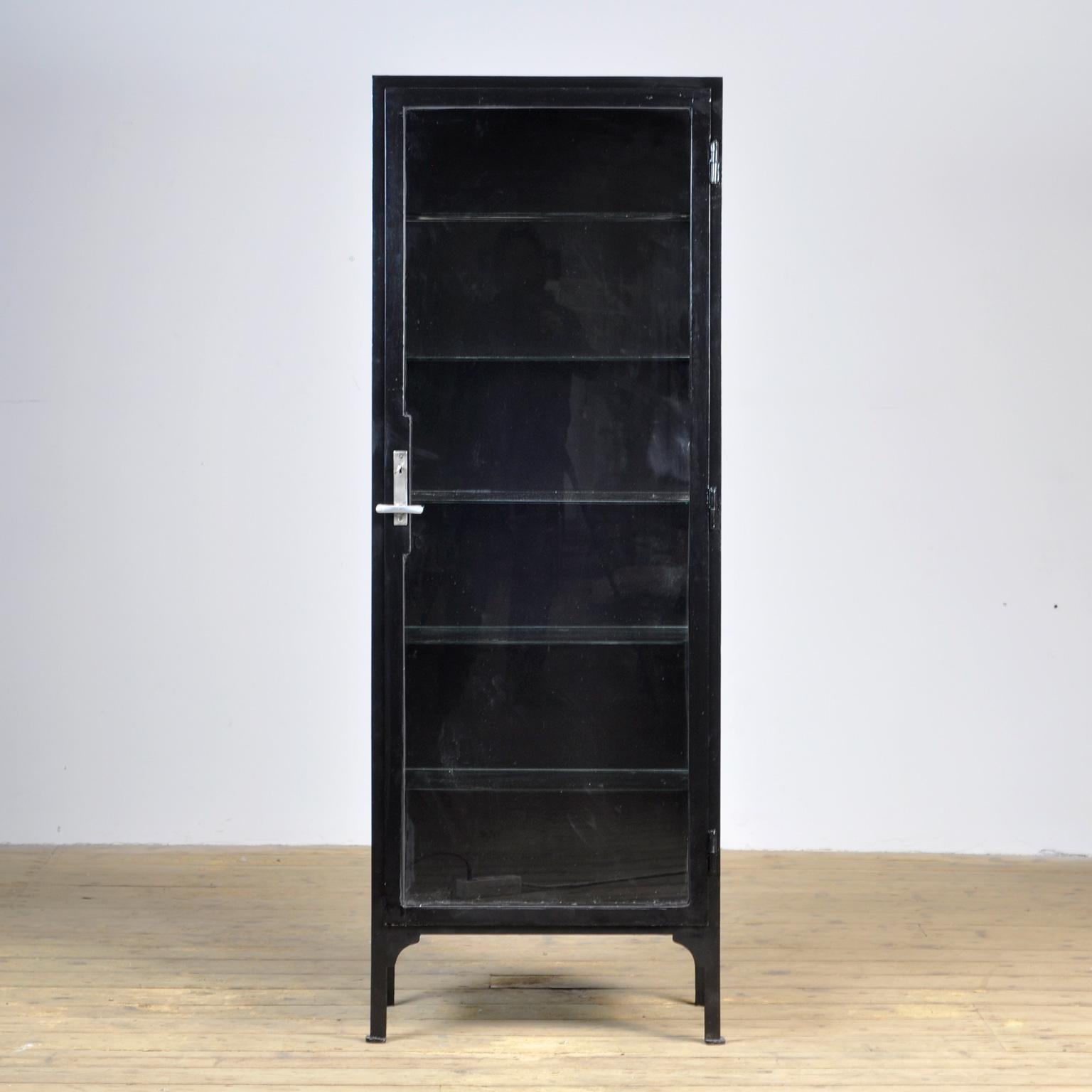 This medicine cabinet was produced in the 1940s in Hungary. The cabinet is made from thick steel and glass. It features five glass shelves.
De cabinet has been lacquered black recently.