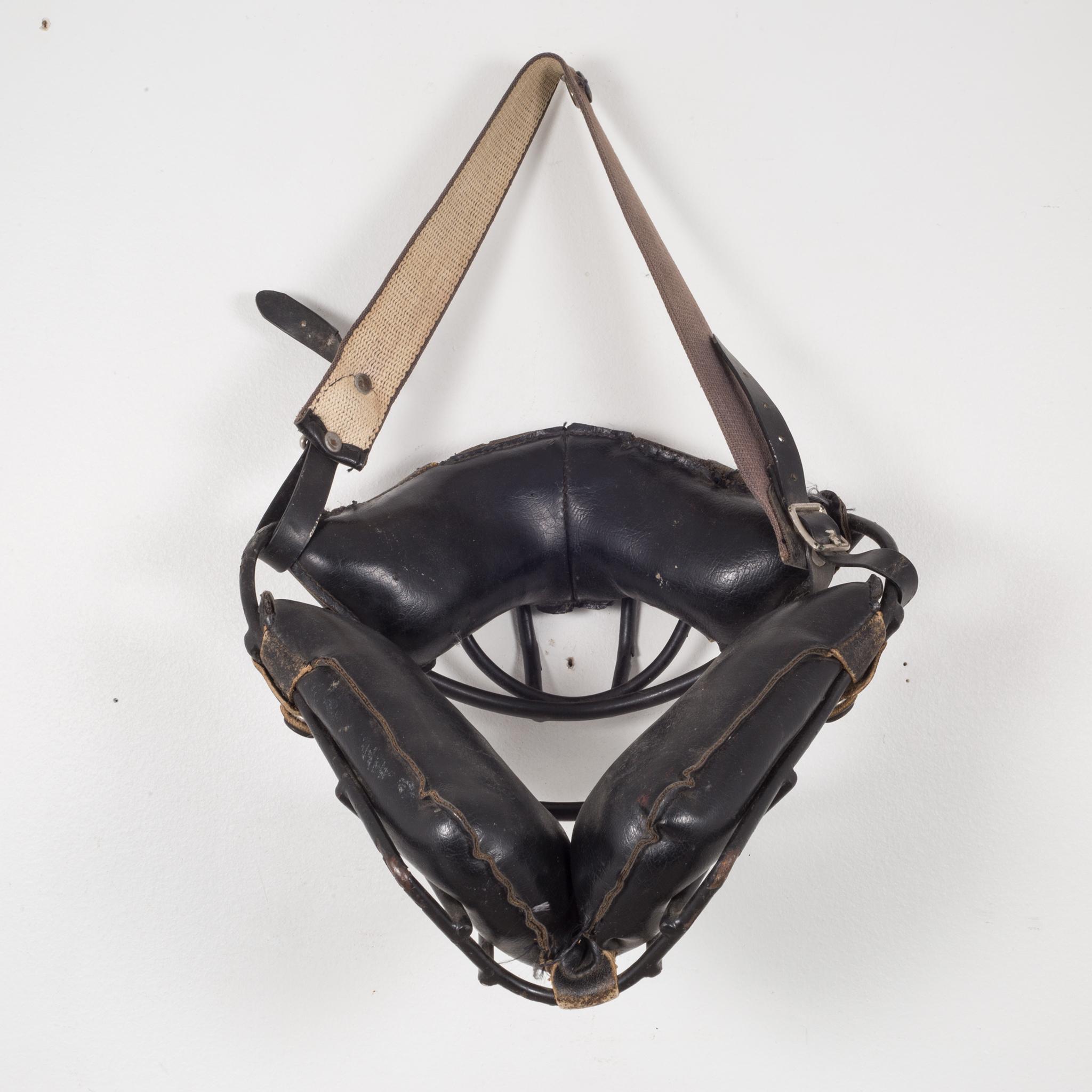 About

This is an original vintage catcher's mask. The main body is steel with thick, black leather padding and fabric head strap. The padding is held onto the body of the mask by leather straps with brass snaps. The piece has retained most of