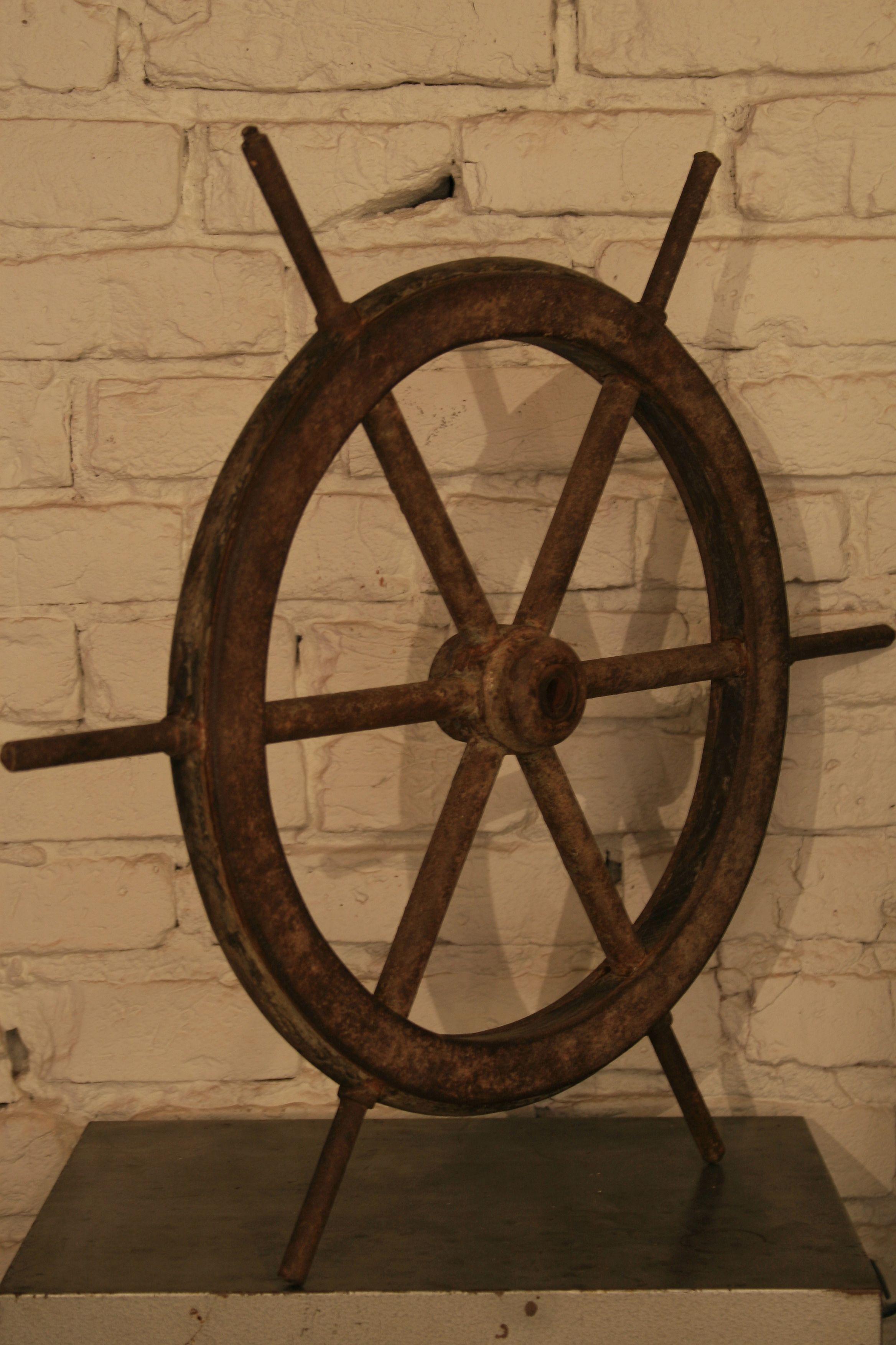 The original antique steering wheel from a fishing boat or a ship.
Steel structure, profiled wood inside the wheel frame, rims screwed with bolts. Preserved remains of the original paint, the whole covered with a beautiful patina of