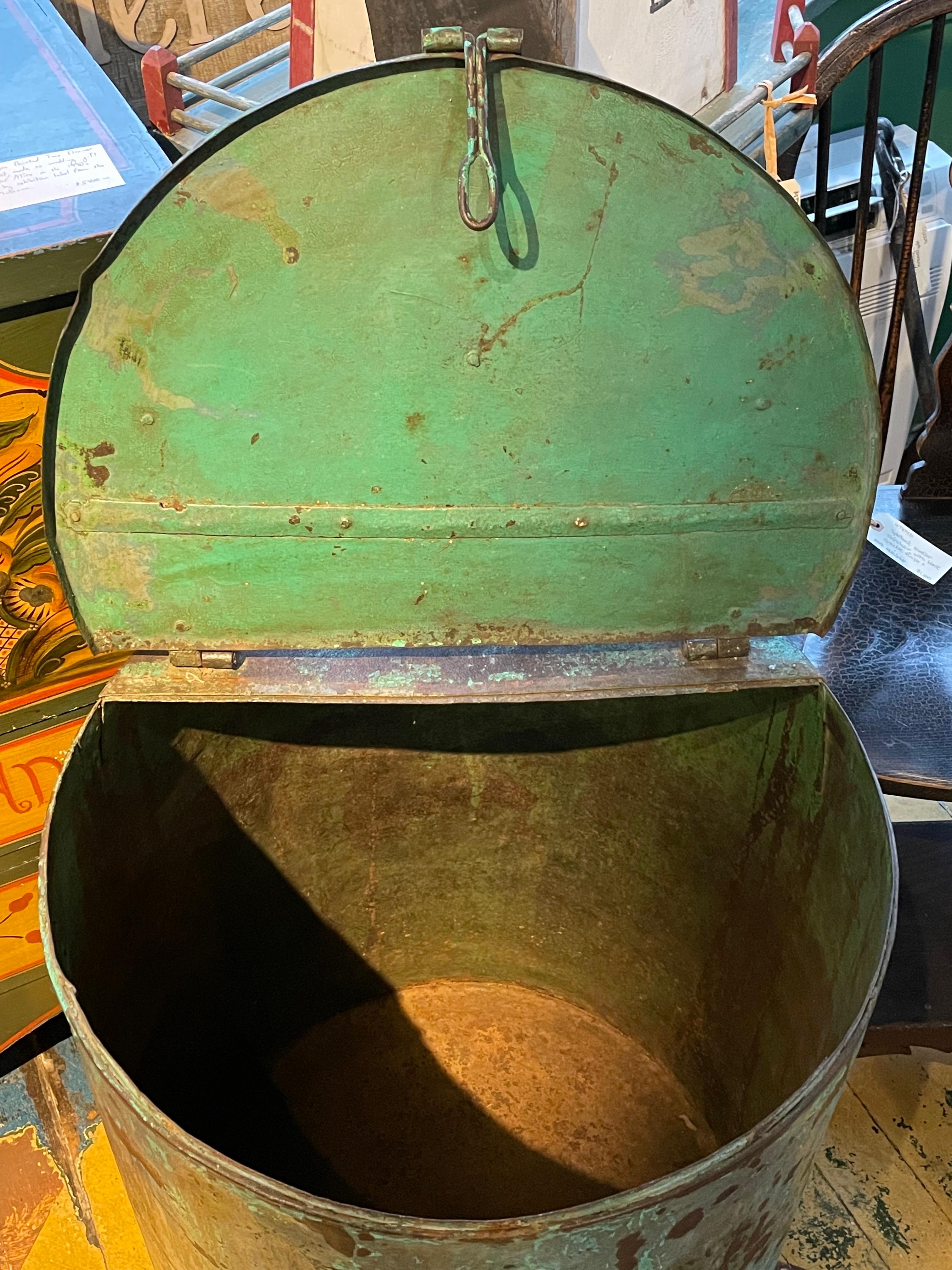 Unusual steel drum with hinged lift top and locking hasp, likely used as a storage bin at some point.  With applied turquoise/faux verdigris paint wash.  