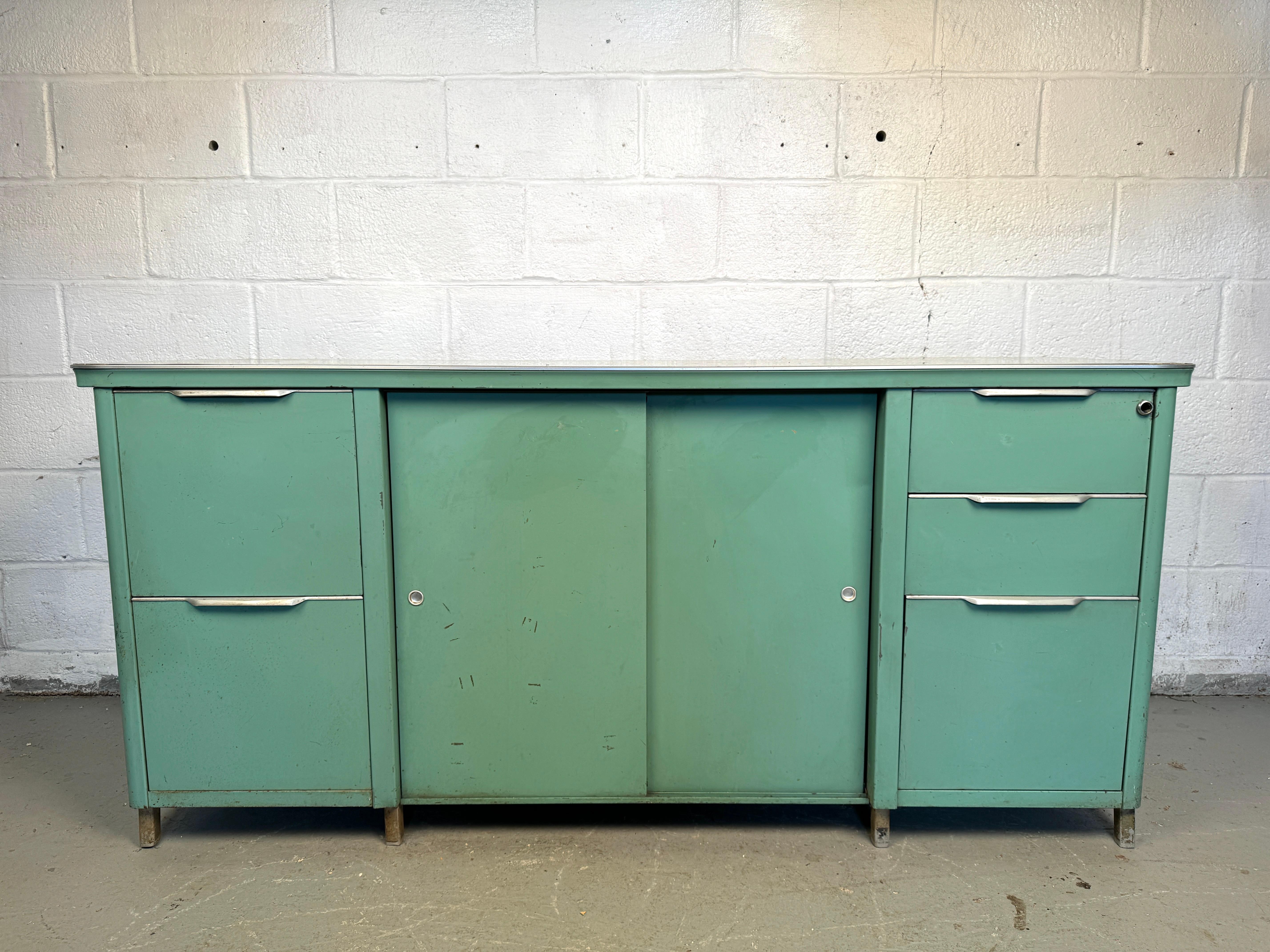 Add some Industrial charm and timeless functionality to your workspace with this Vintage Steel Tanker Office Cabinet. Originally designed for durability and efficiency, this iconic piece is a perfect blend of vintage appeal and modern utility.