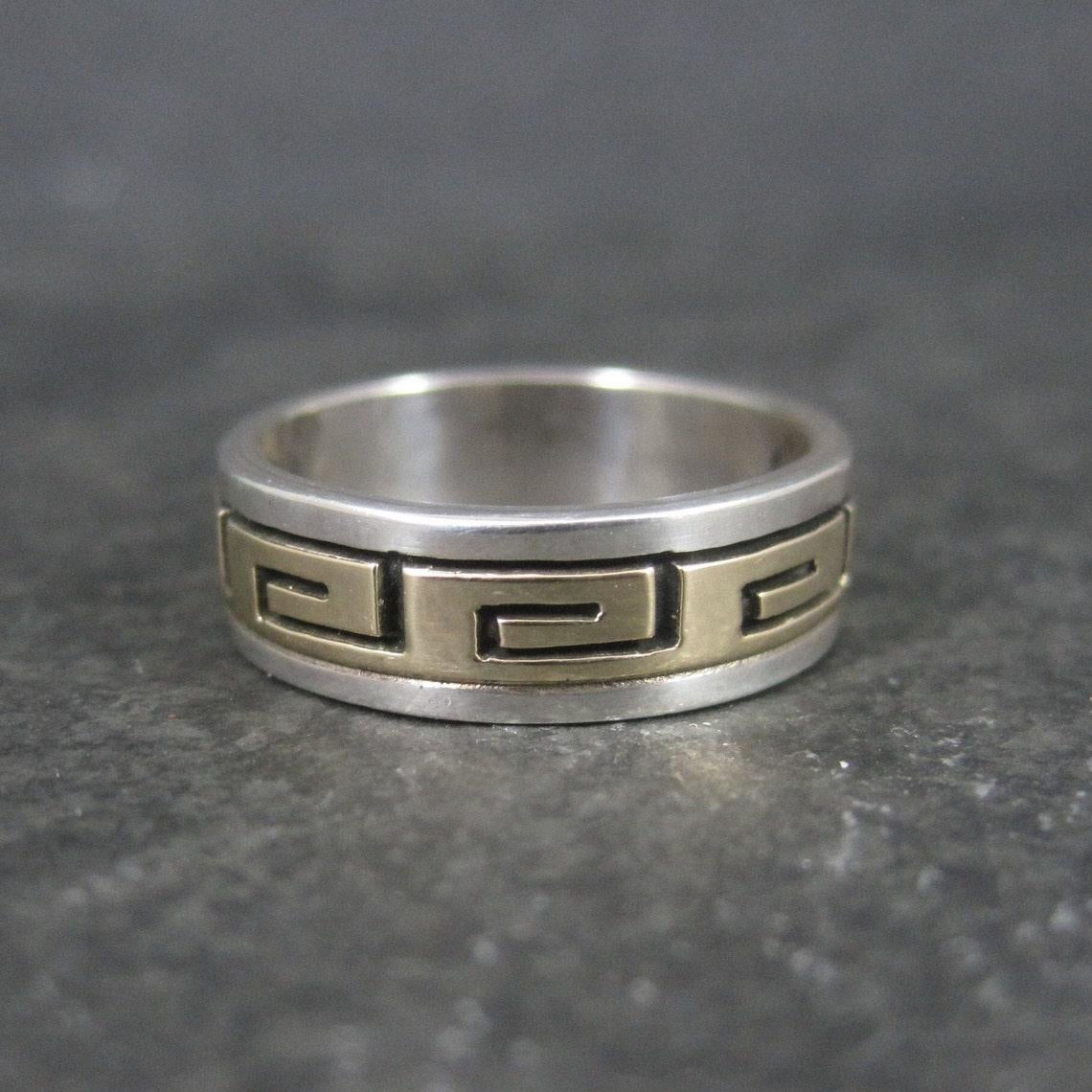 This beautiful band ring is sterling silver and 14k yellow gold.
It is the creation of Navajo silversmith Scott Skeets.

Measurements: 6.5mm wide

Size: 8

Marks: 14K, Sterling, S Skeets

Condition: Excellent