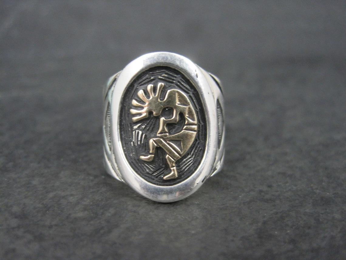 This gorgeous estate ring is sterling silver with a 14K kokopelli.

The face of this ring measures 13/16 of an inch north to south.
Weight: 13.2 grams
Size: Fits like a 5.75

Marks: Sterling, 14K

Condition: Polished and ready to wear
