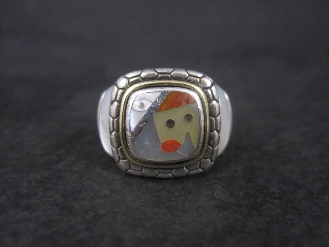 This gorgeous estate ring is a product of Eric Grossbardt.
It is sterling silver with 18k yellow gold accenting and features picasso like inlay in mother of pearl, abalone and spiny oyster.

The face of this ring measures 5/8 of an inch north to