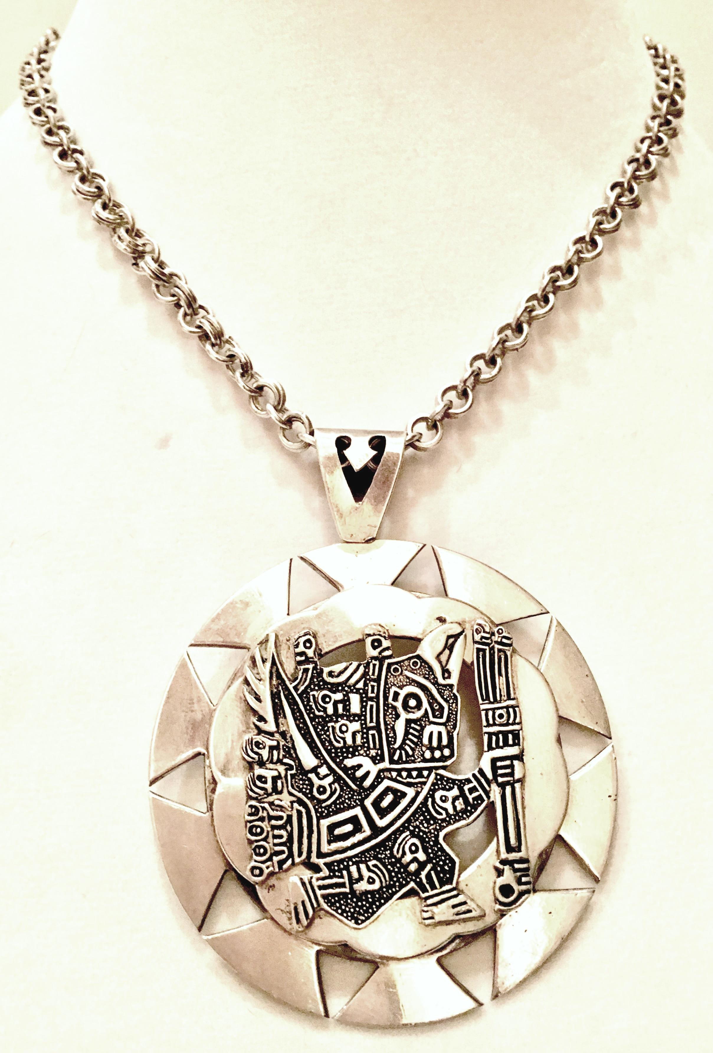 Mid-Century Sterling Silver 925 double layer dimensional sun medallion depicting the Aztec Mythical Sun God in motion pendant necklace. This pendant hangs on a sterling silver double link chain with hook and ball closure. The medallion or pendant is