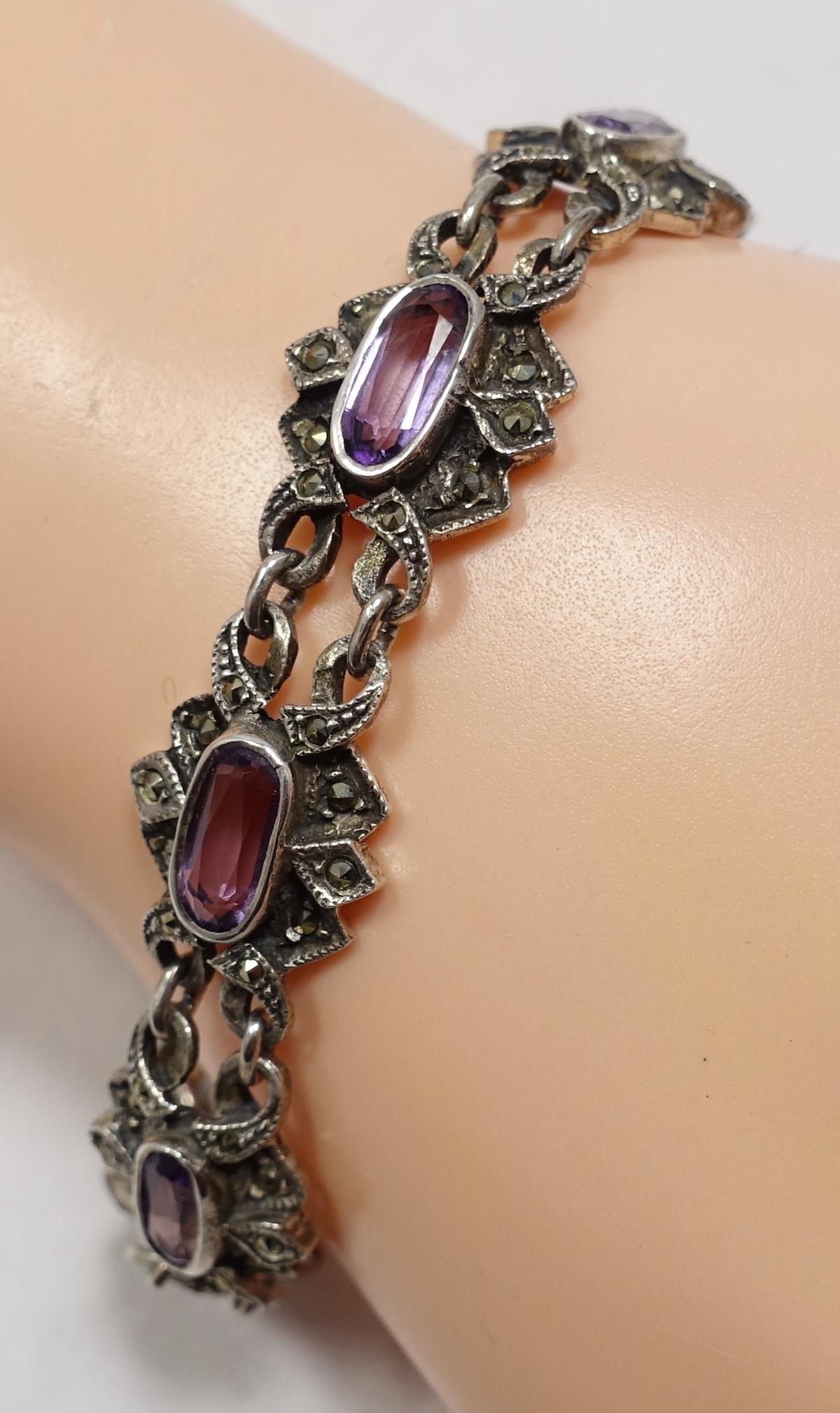 This vintage sterling silver bracelet has elongated amethyst stones in a marcasite with an open link design. This bracelet measures 7-1/2” x 3/4” with a fold-over clasp and is in excellent condition.