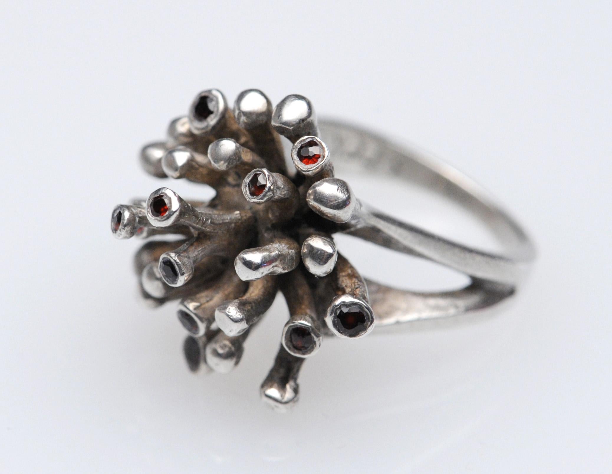 Appealing circa 1970s Modernist ring crafted in sterling silver with Garnett details and marked Opus Ster. High quality design and execution. Size is 7.25.